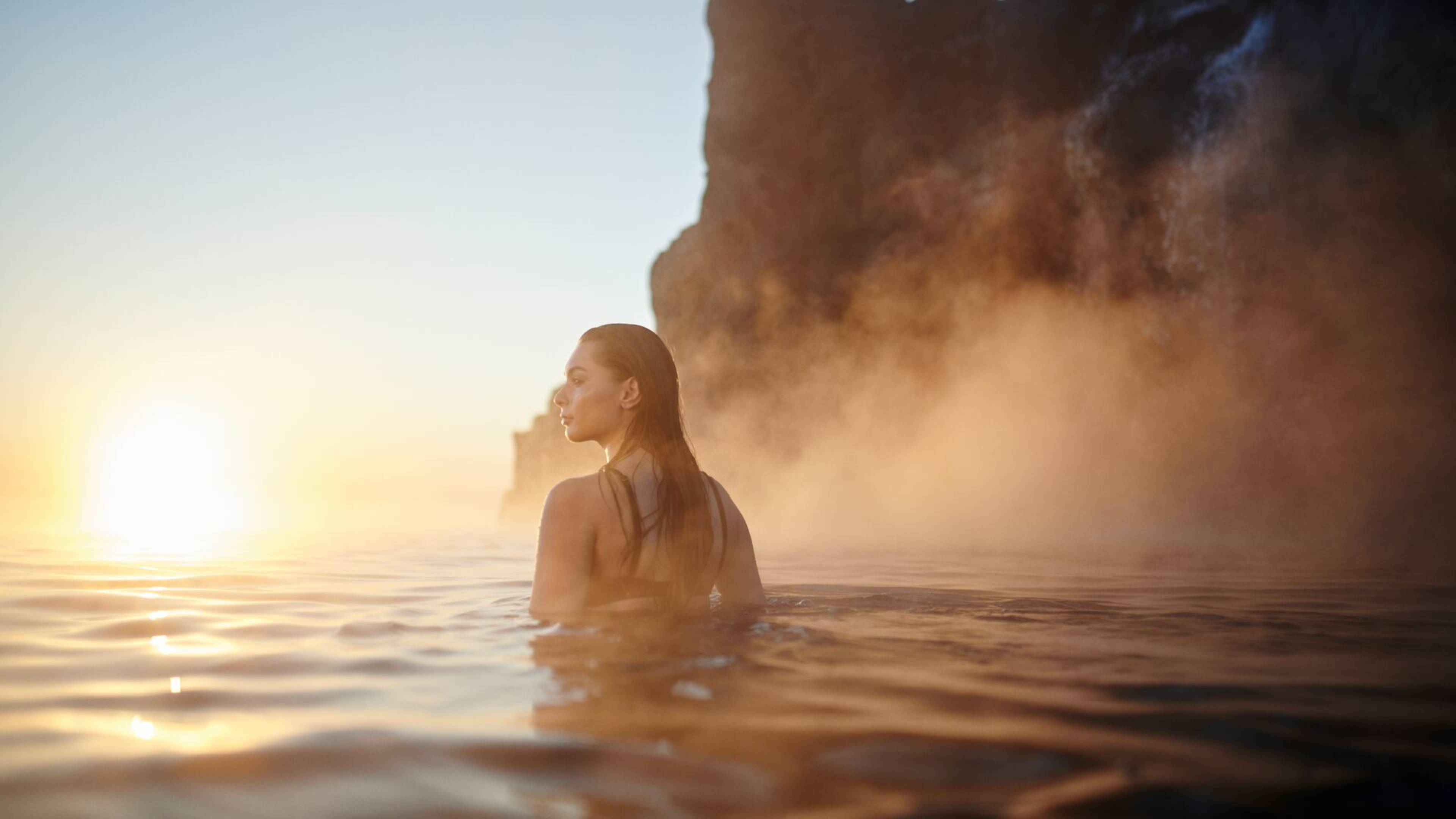 Woman in Sky Lagoon at sunset.