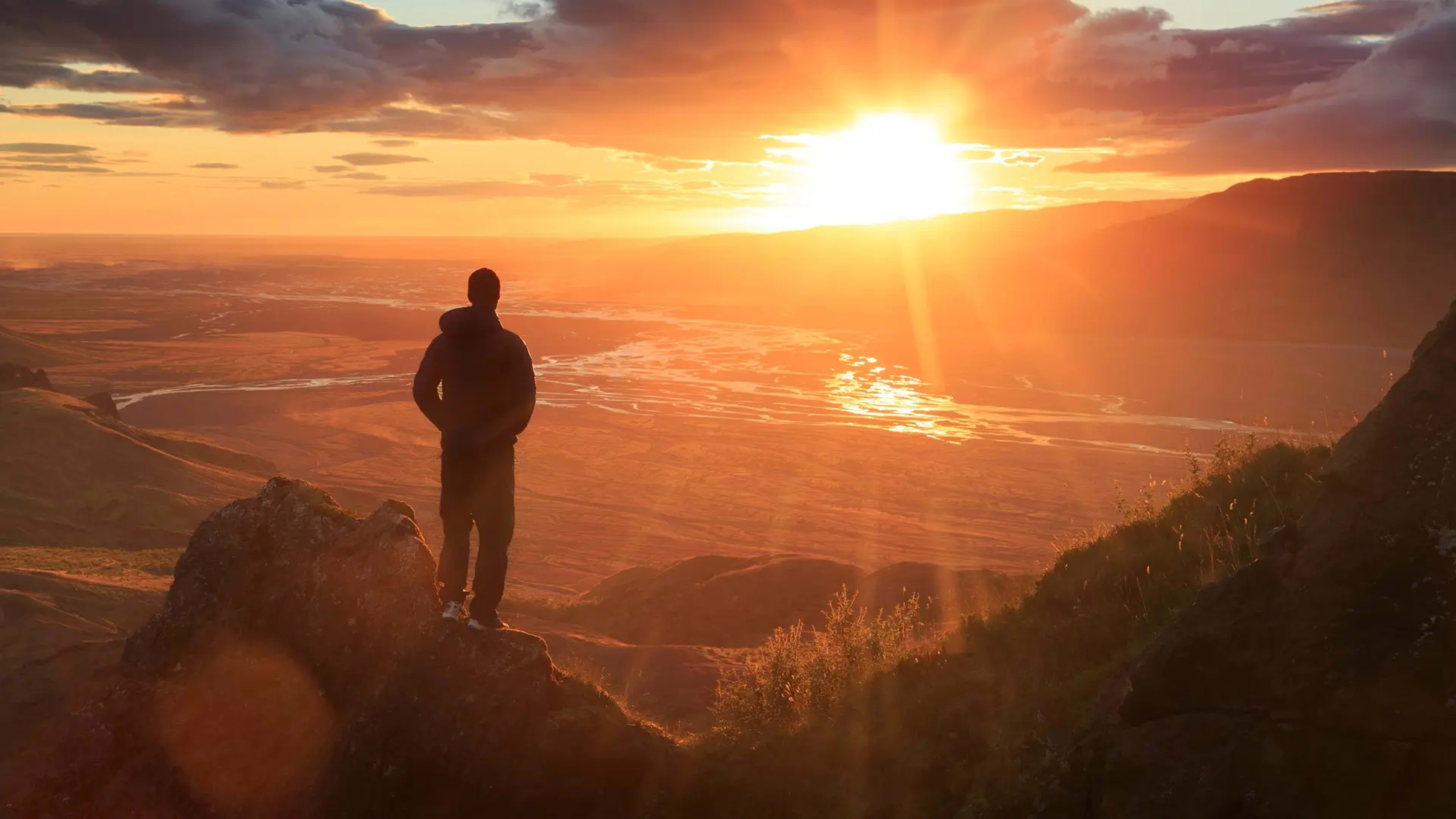 A hiker looking at the sunset over Thorsmork valley, Iceland