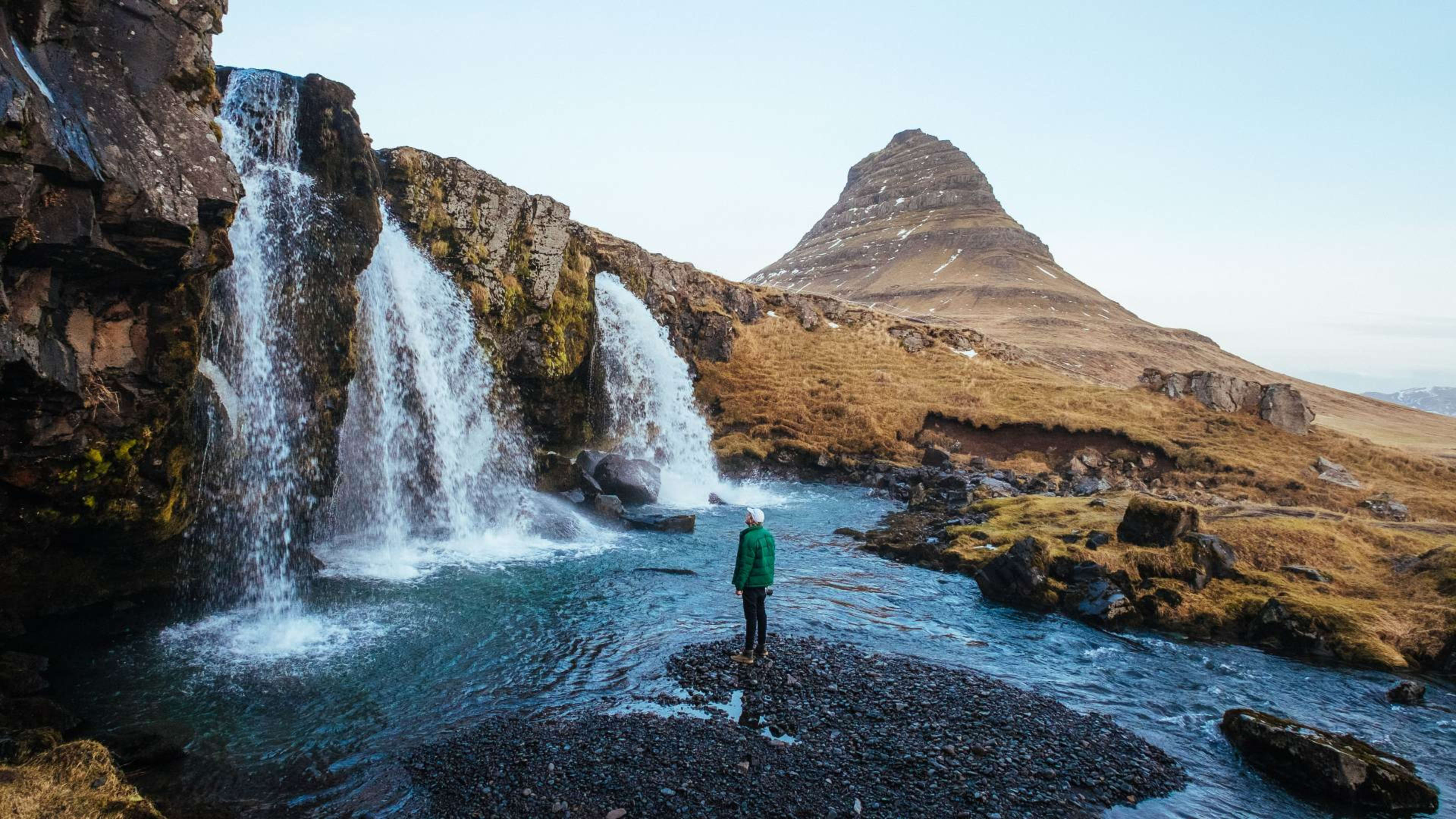 A man standing below Kirkjufellsfoss