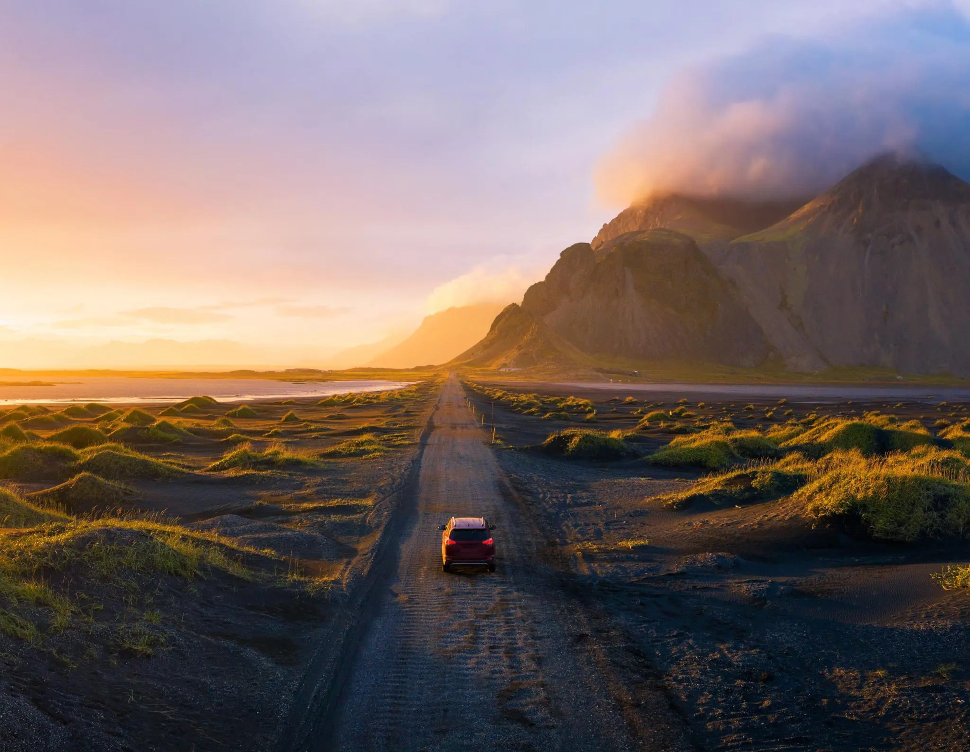 Car driving into the sunset in East Iceland