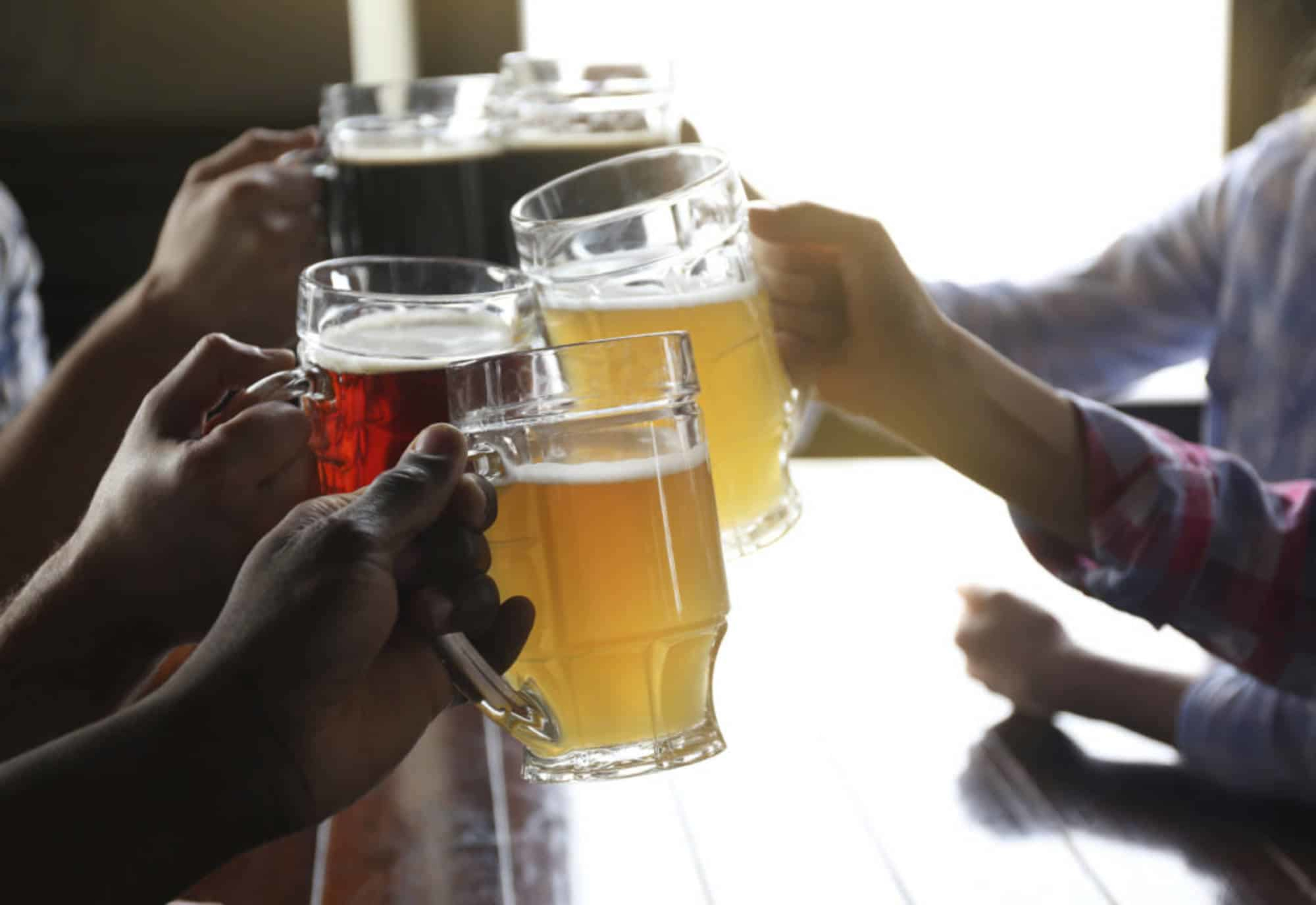 5 beers of different colours clinking for a cheer