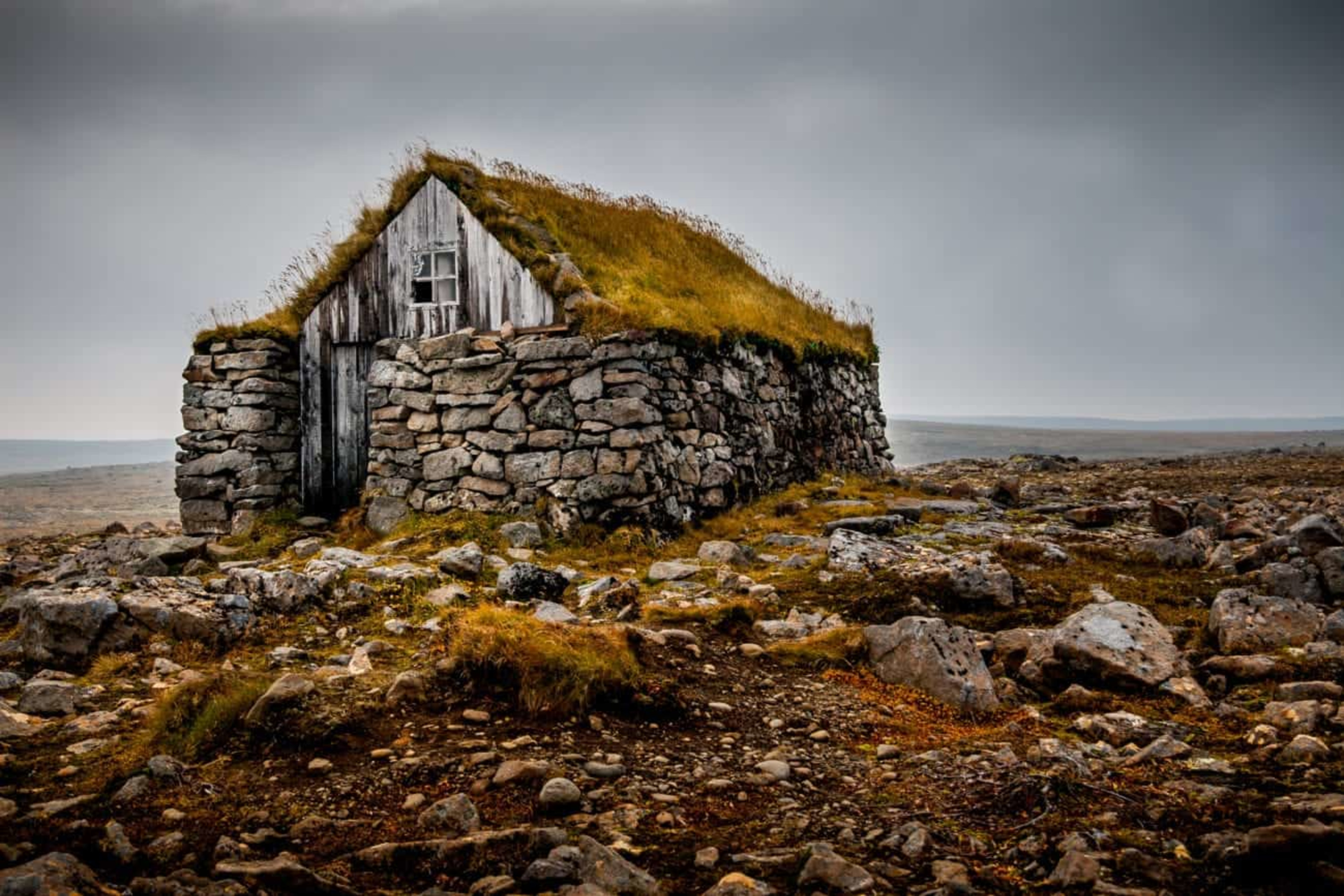 turf house with stone walls in rocky lava field