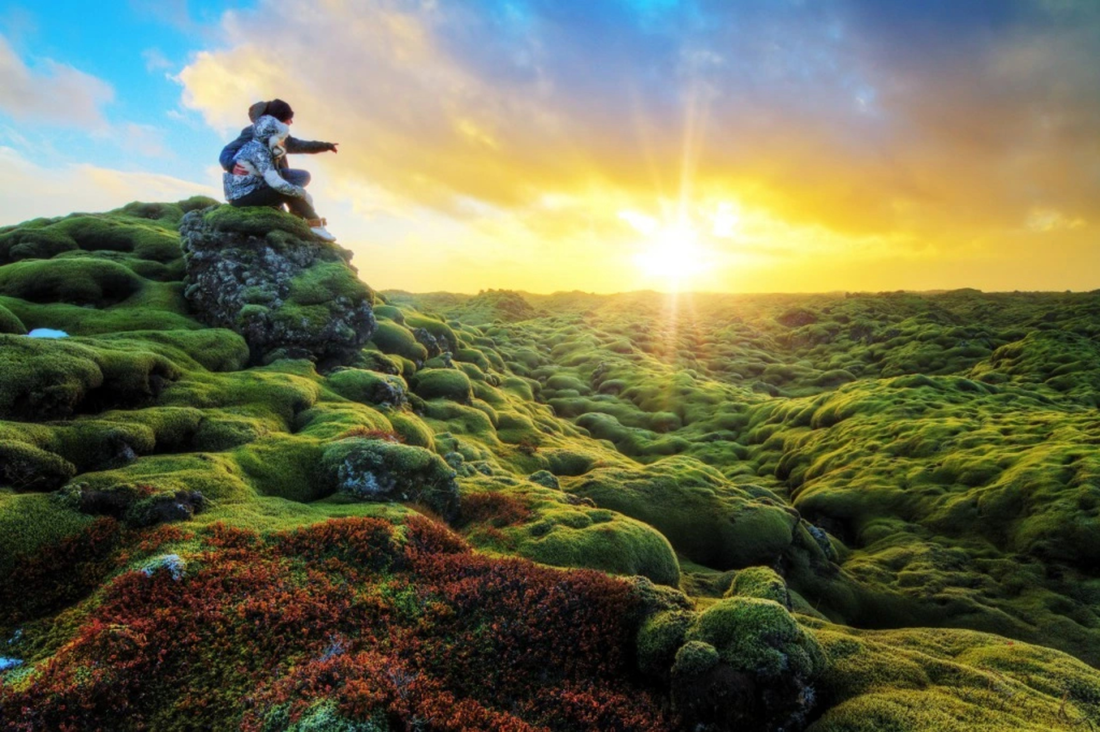 Couple enjoying the view of lava field covered by green moss