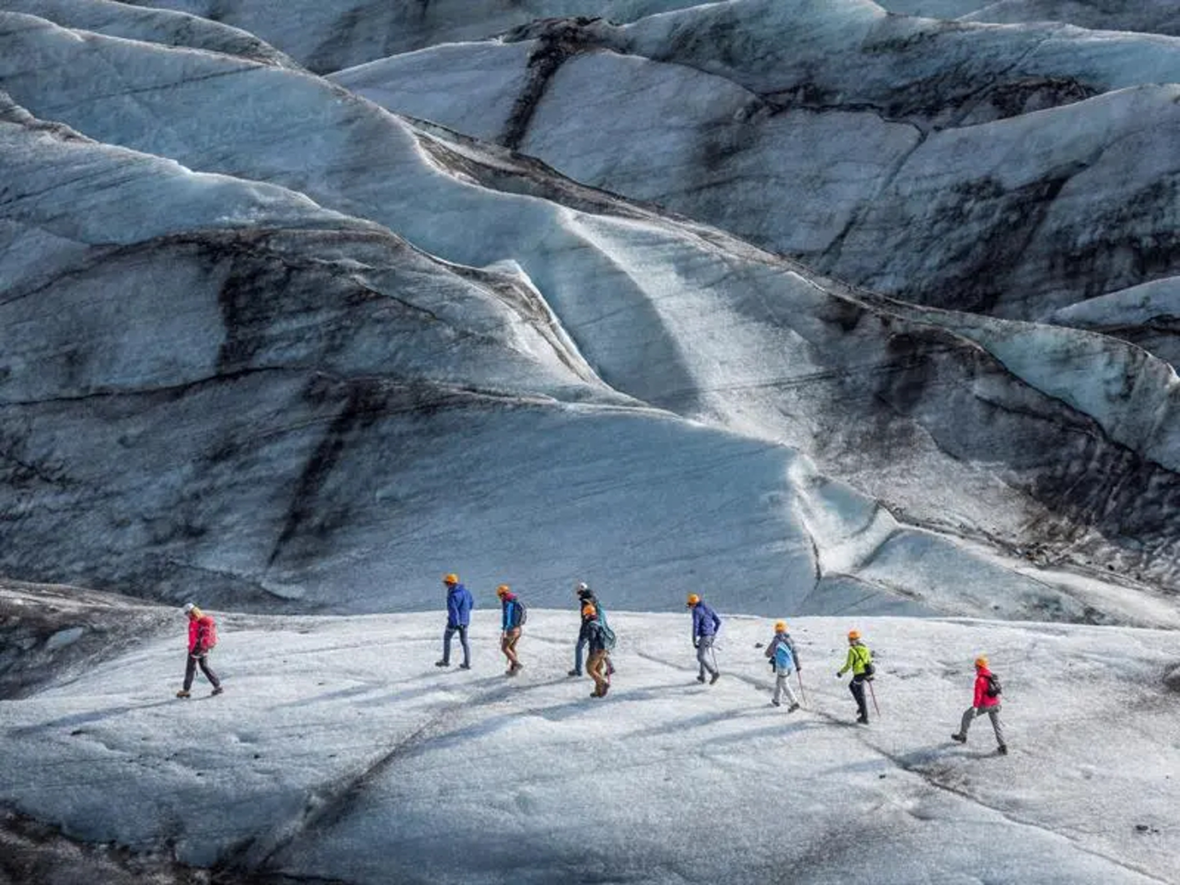 Group of people walking on a glacier