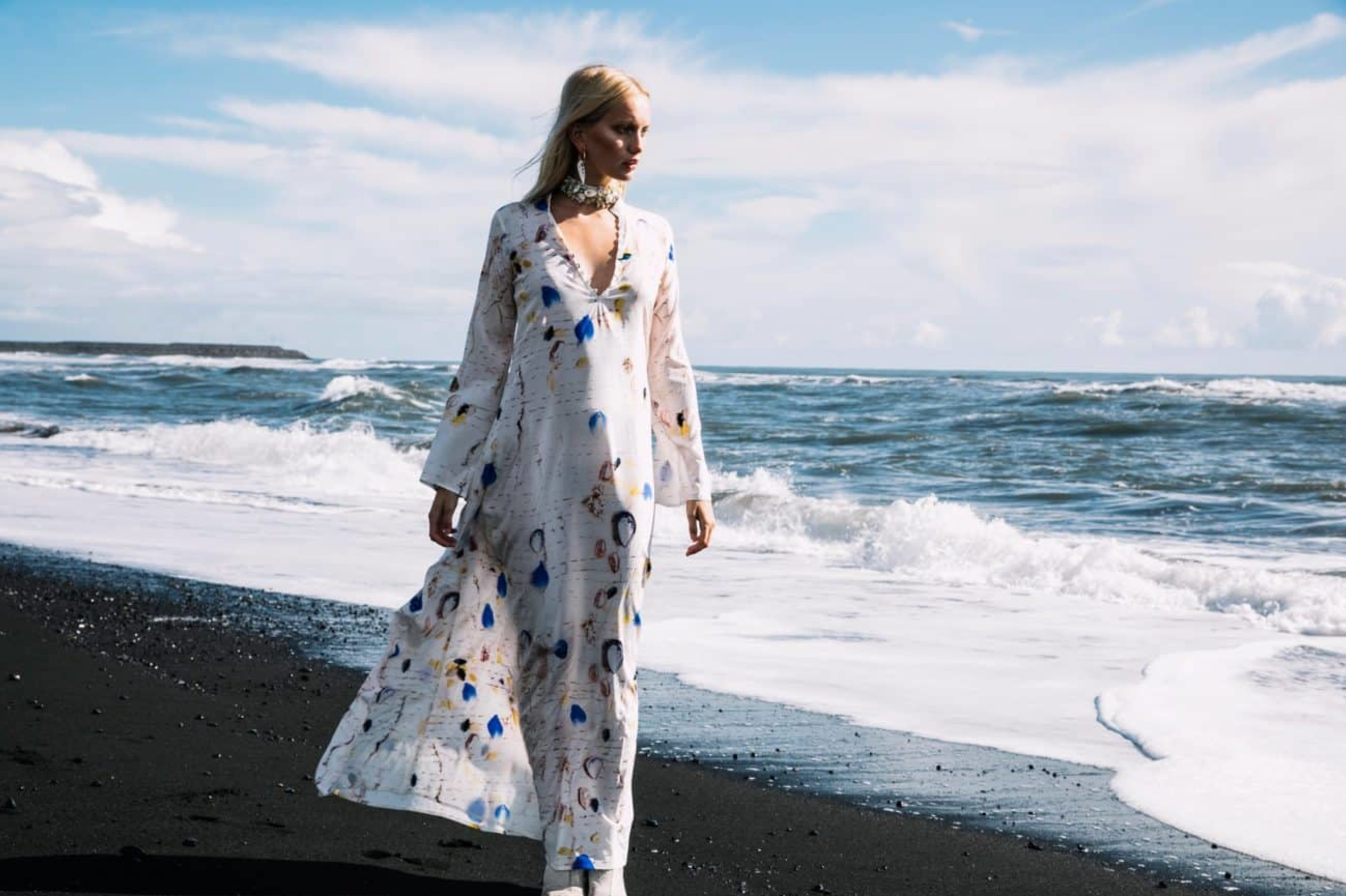 A well dressed woman walking on a beach