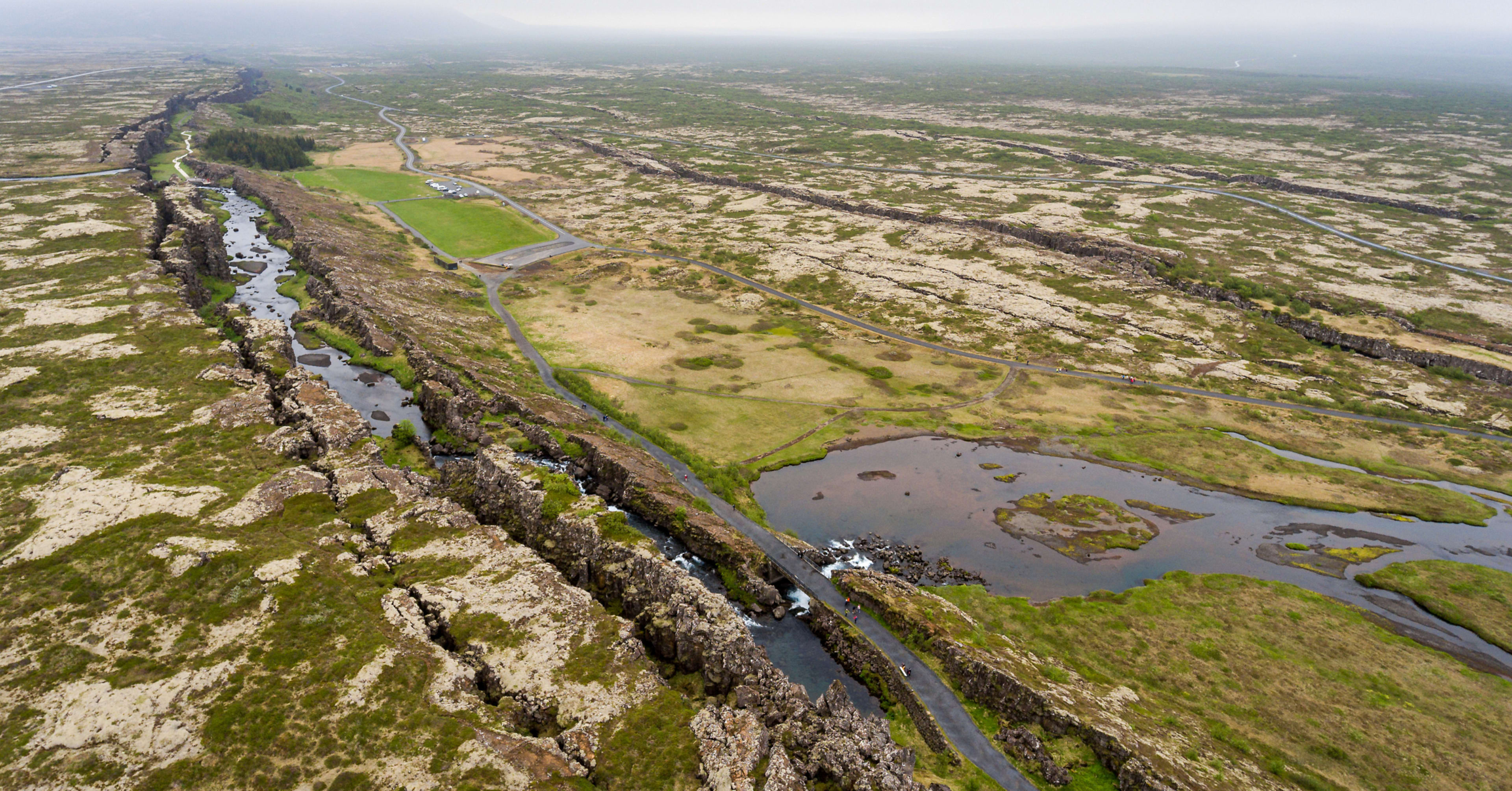 Wide aerial shot of the Silfra fissure area and visitor paths at Thingvellir