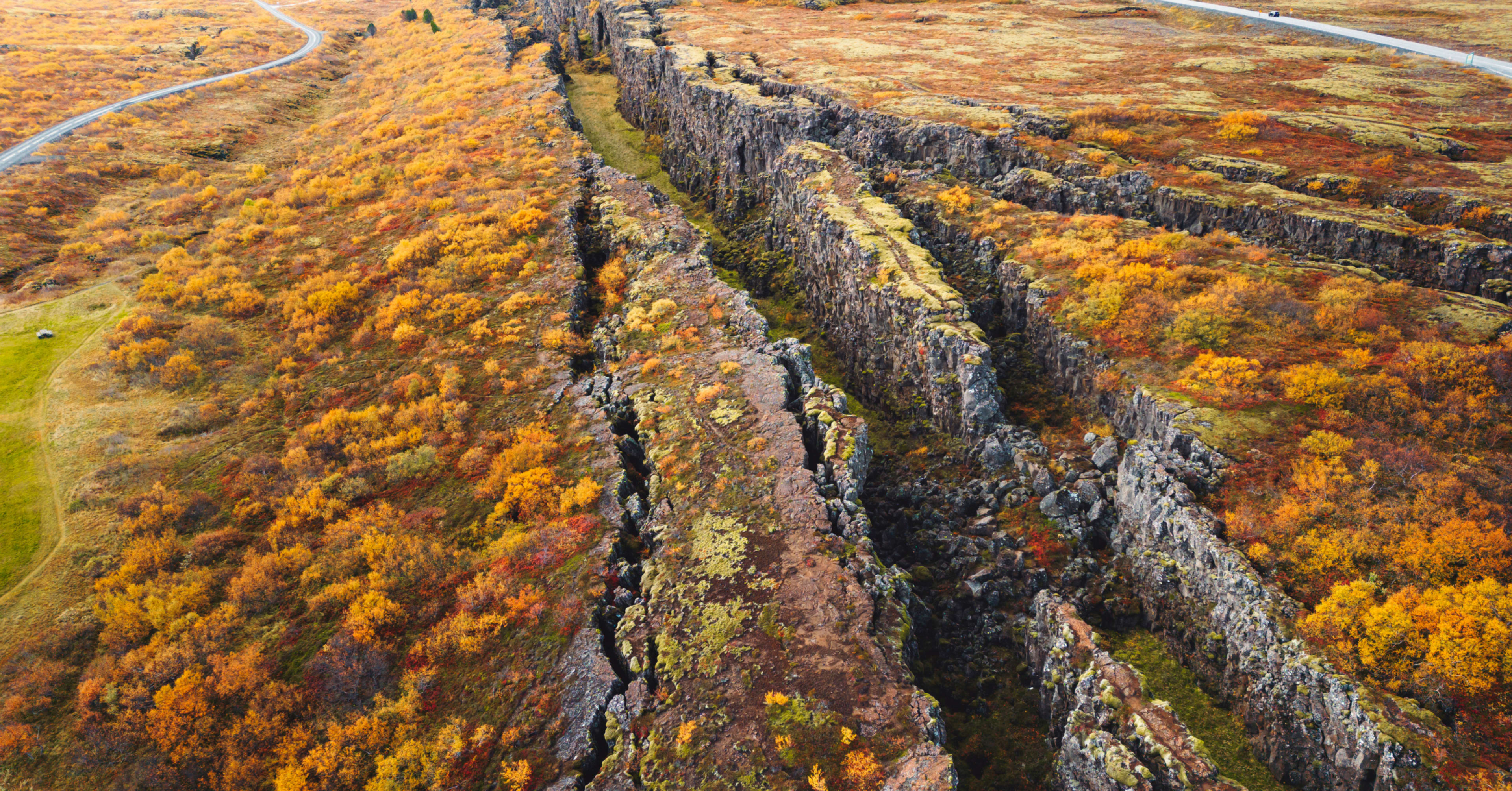 Aerial view of Thingvellir’s autumn rift valley with golden-orange shrubs