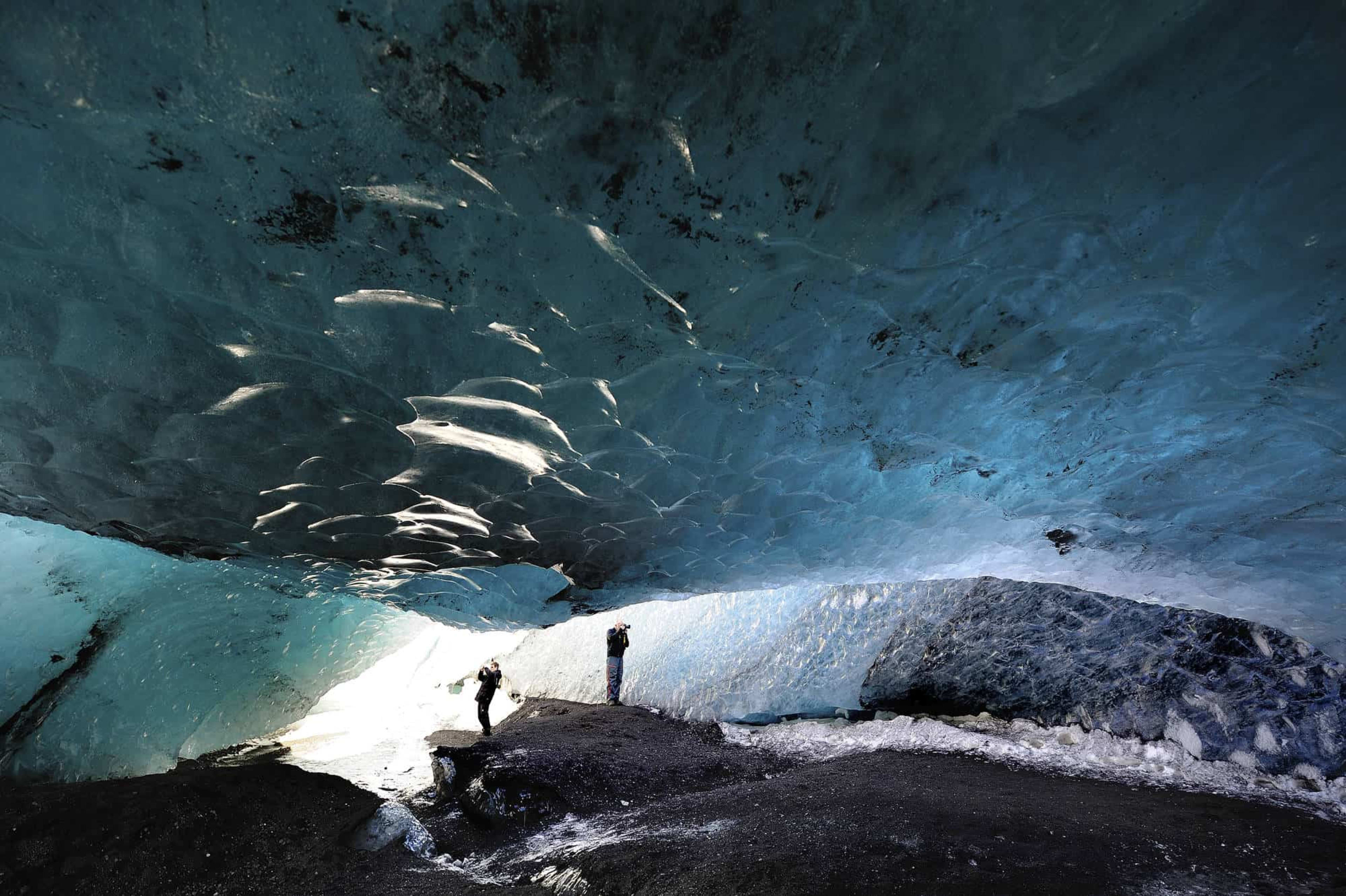 People exploring glacier cave