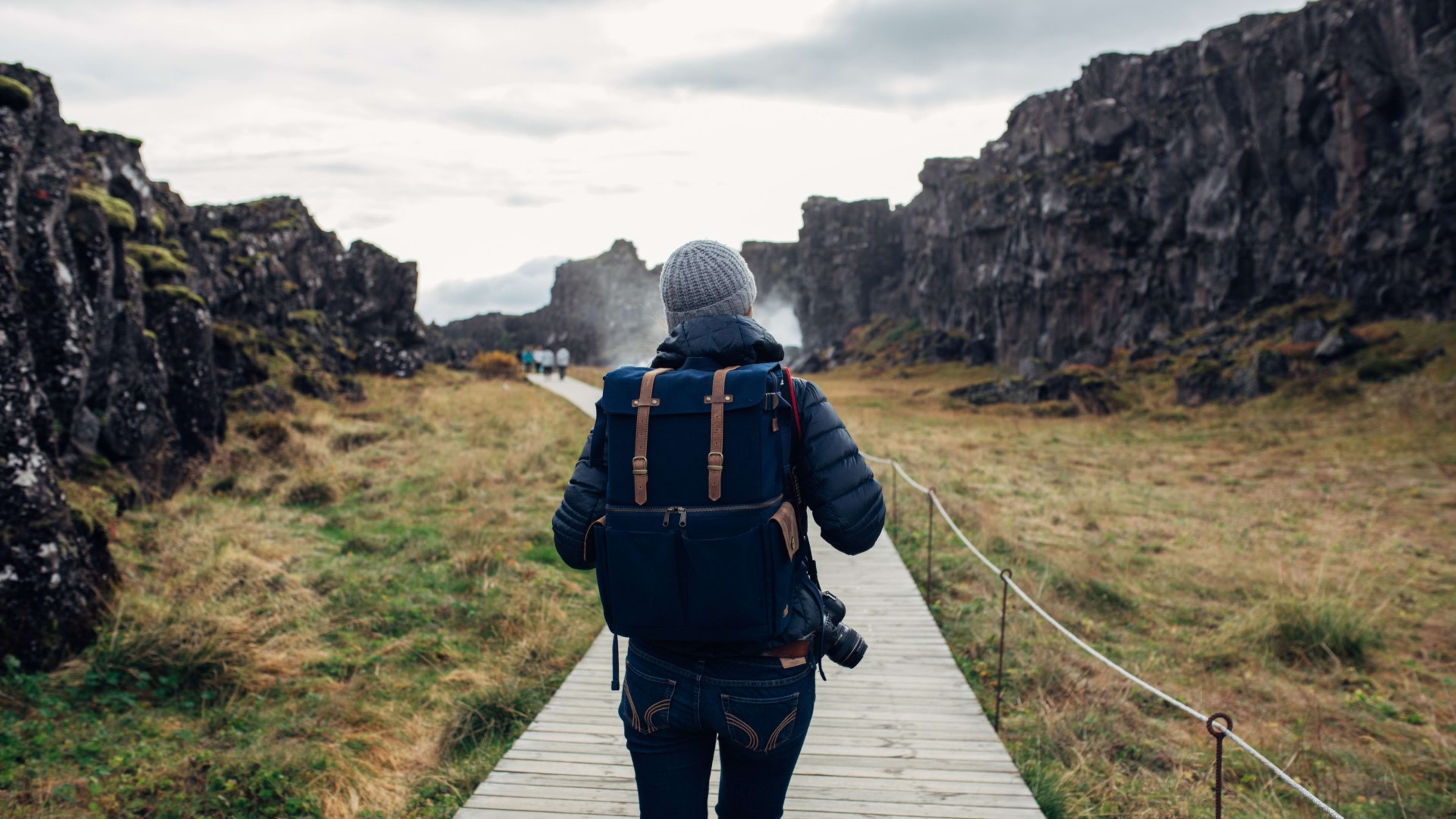 Woman standing at Seljalandsfoss waterfall