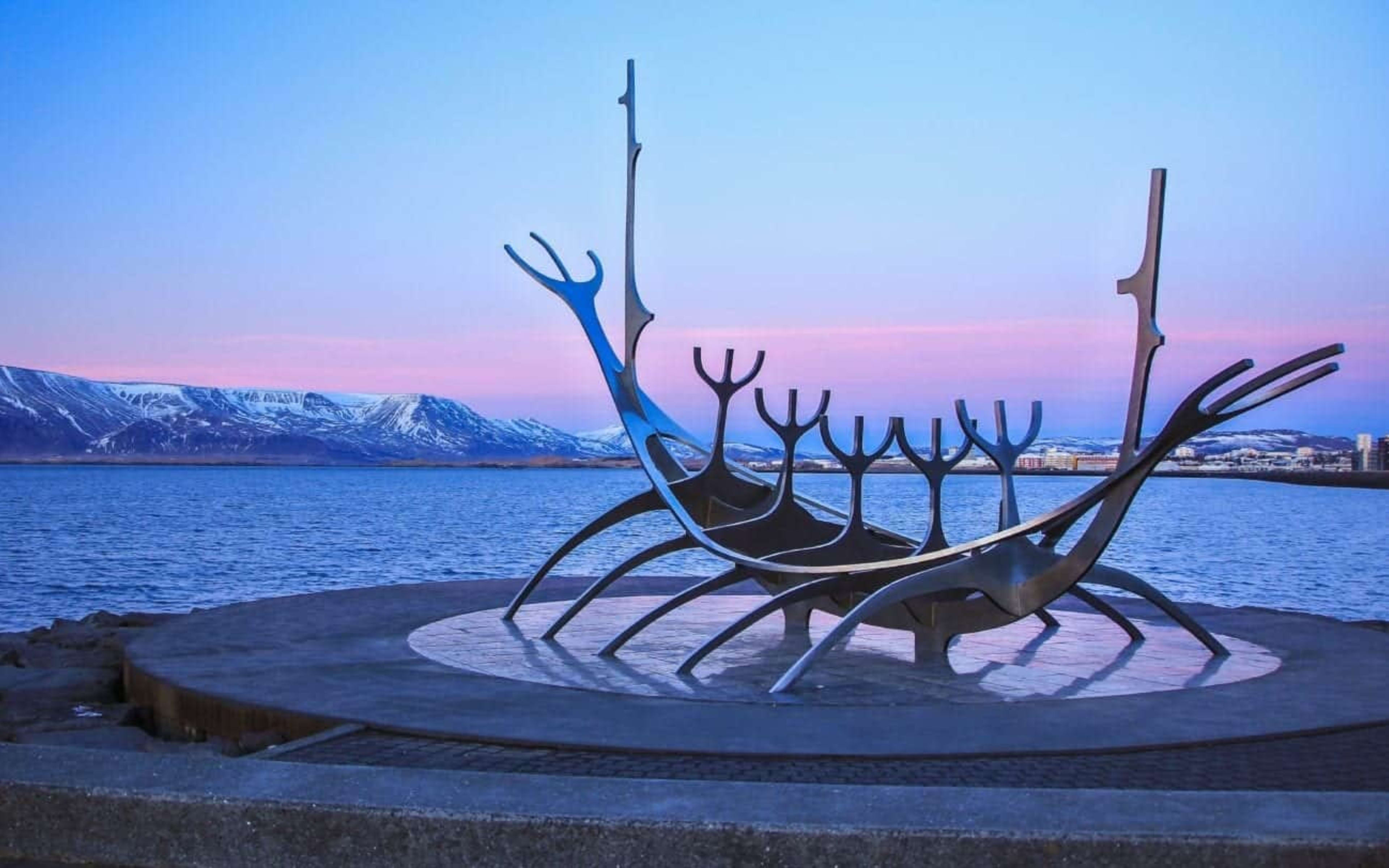 The Sun Voyager sculpture in Reykjavík with snowy mount Esja in the background