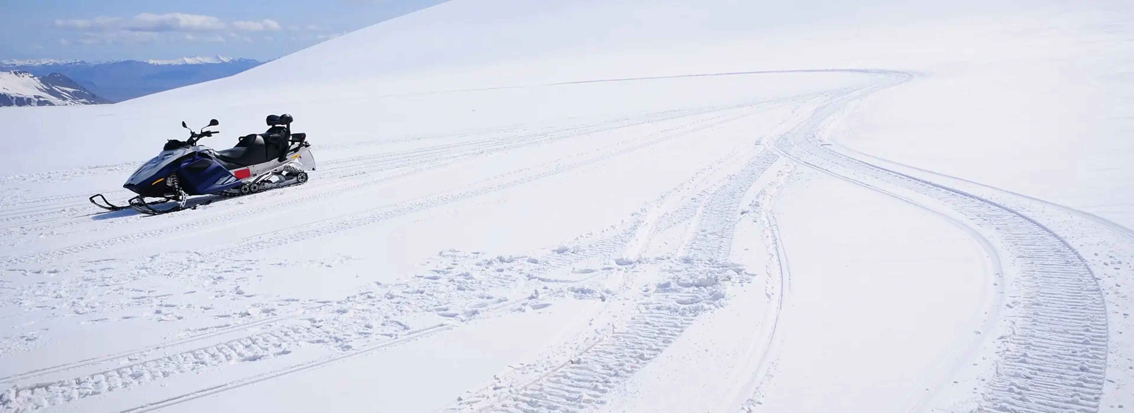 a snowmobile sitting on snowy landscape