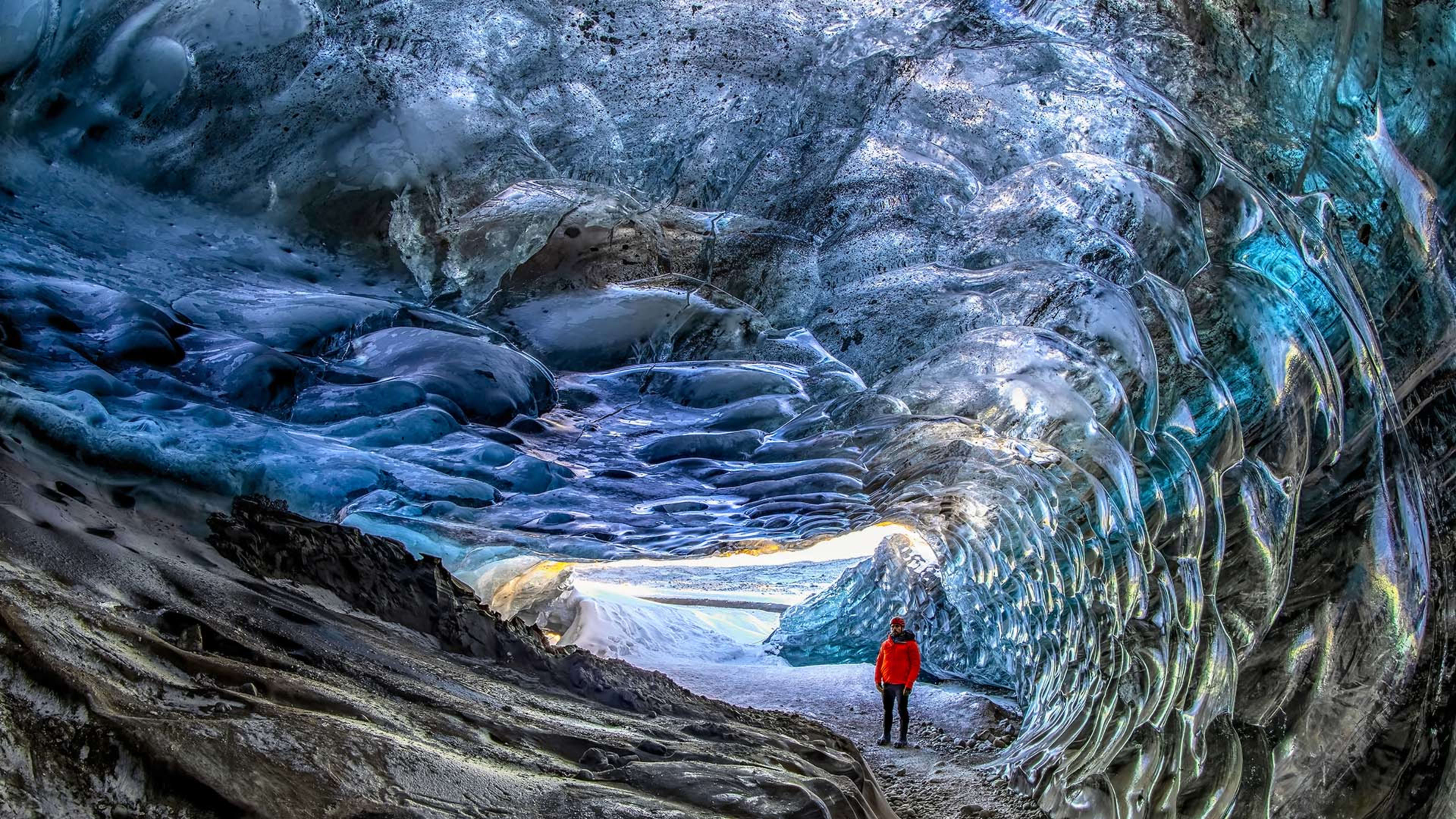 A man inside an ice cave on the Crystal Ice Cave Tour