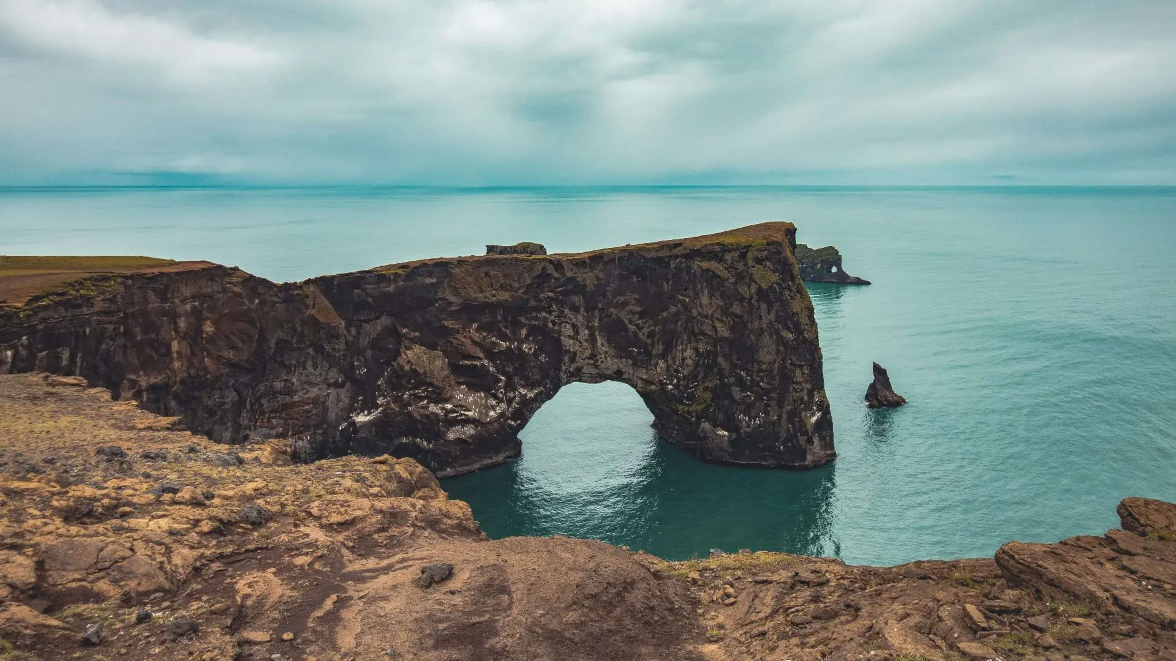 rocky arch cliff in a turquoise sea