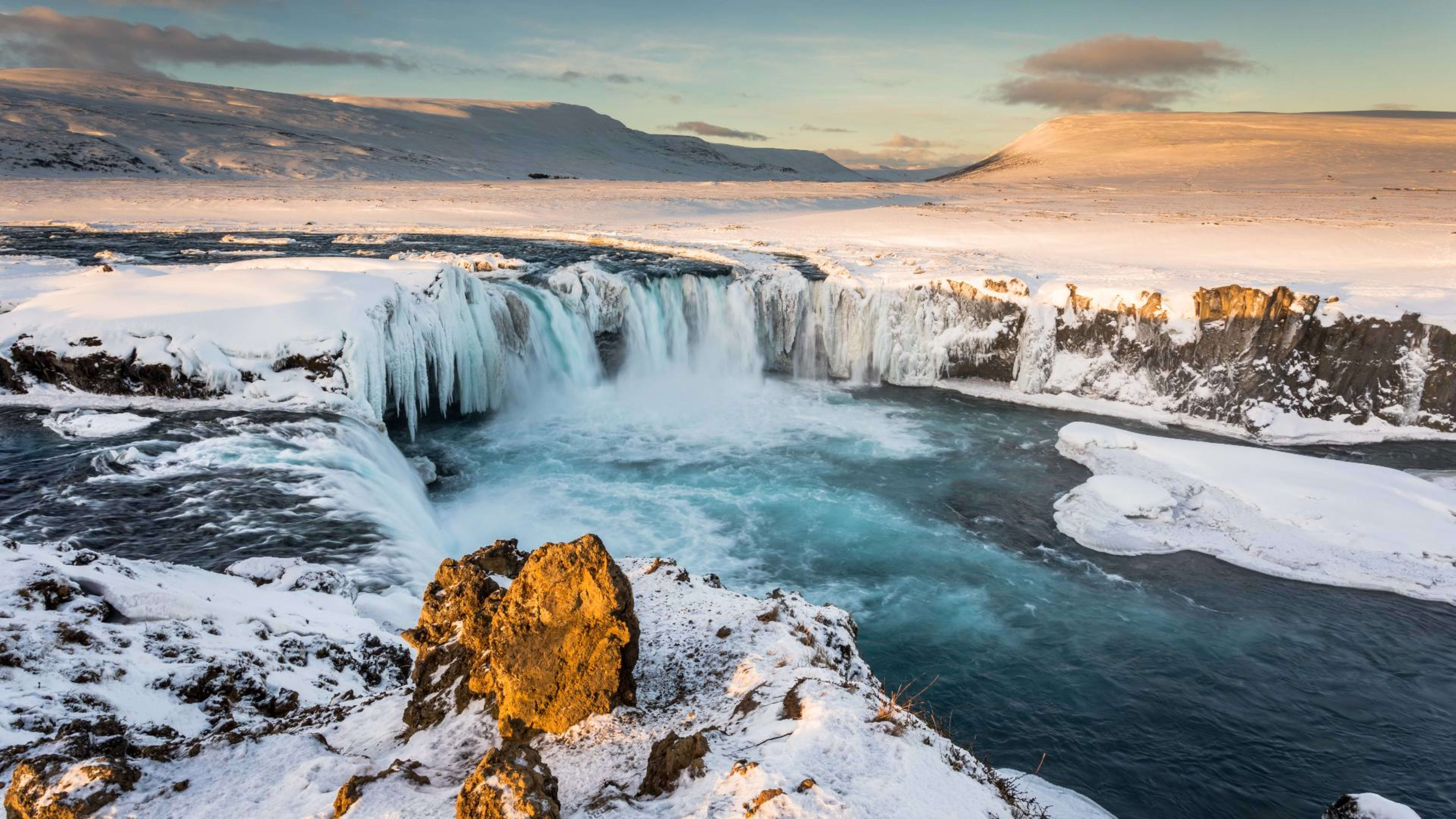 The Goðafoss waterfall during the winter surrounded by snow