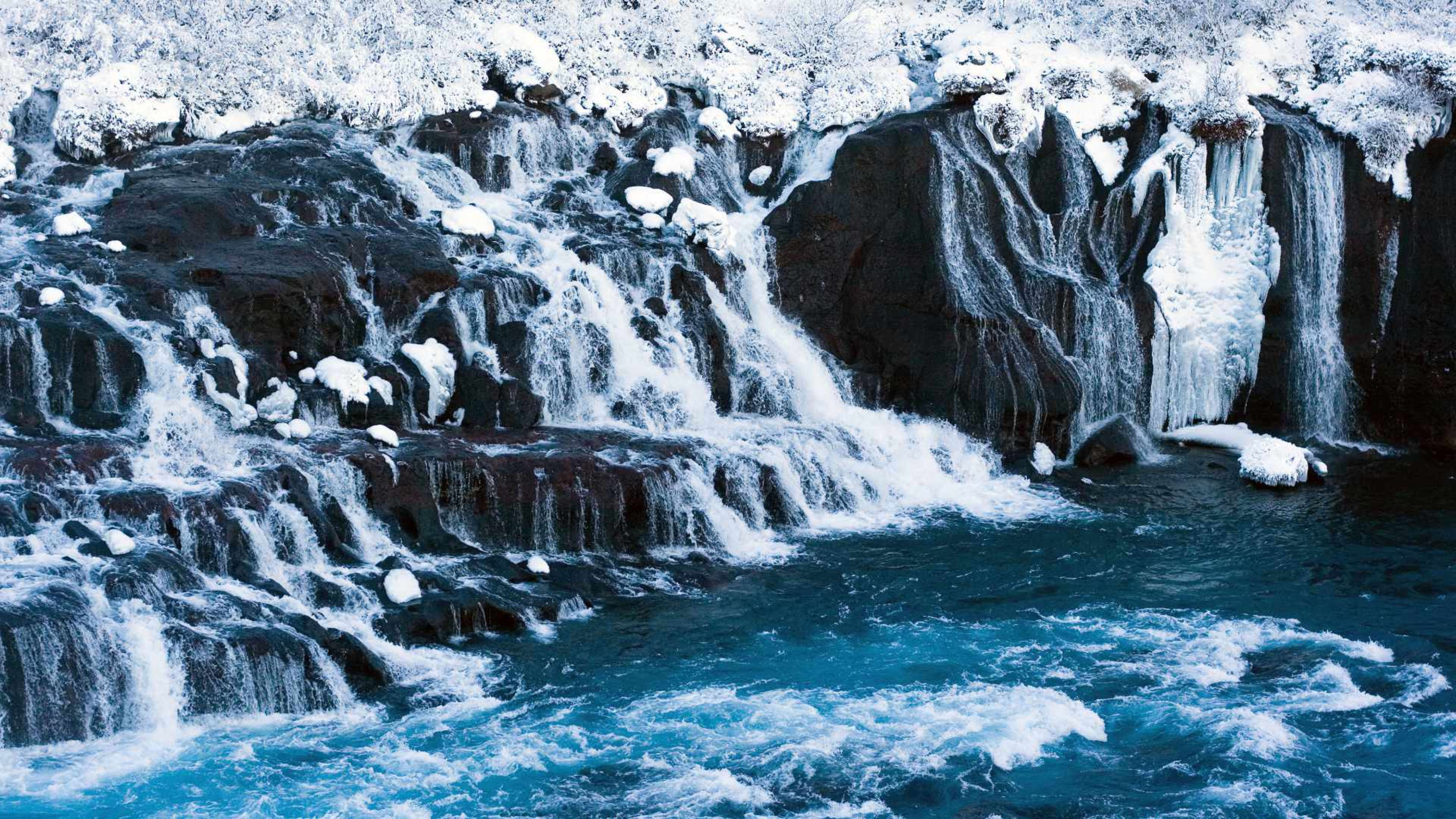 The Hraunfossar waterfall in winter covered in ice