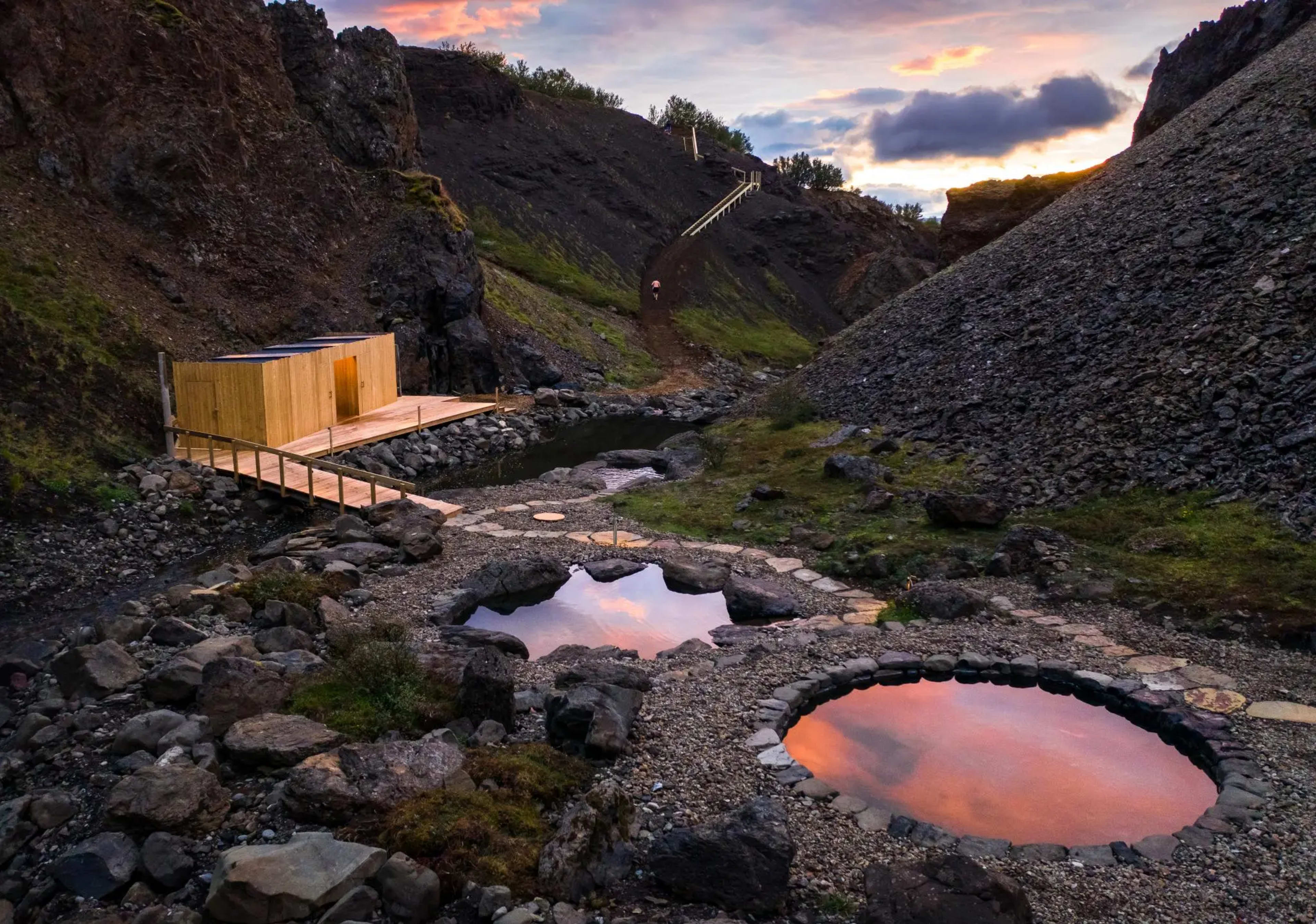 Pink clouds reflecting in the Husafell Canyon Baths