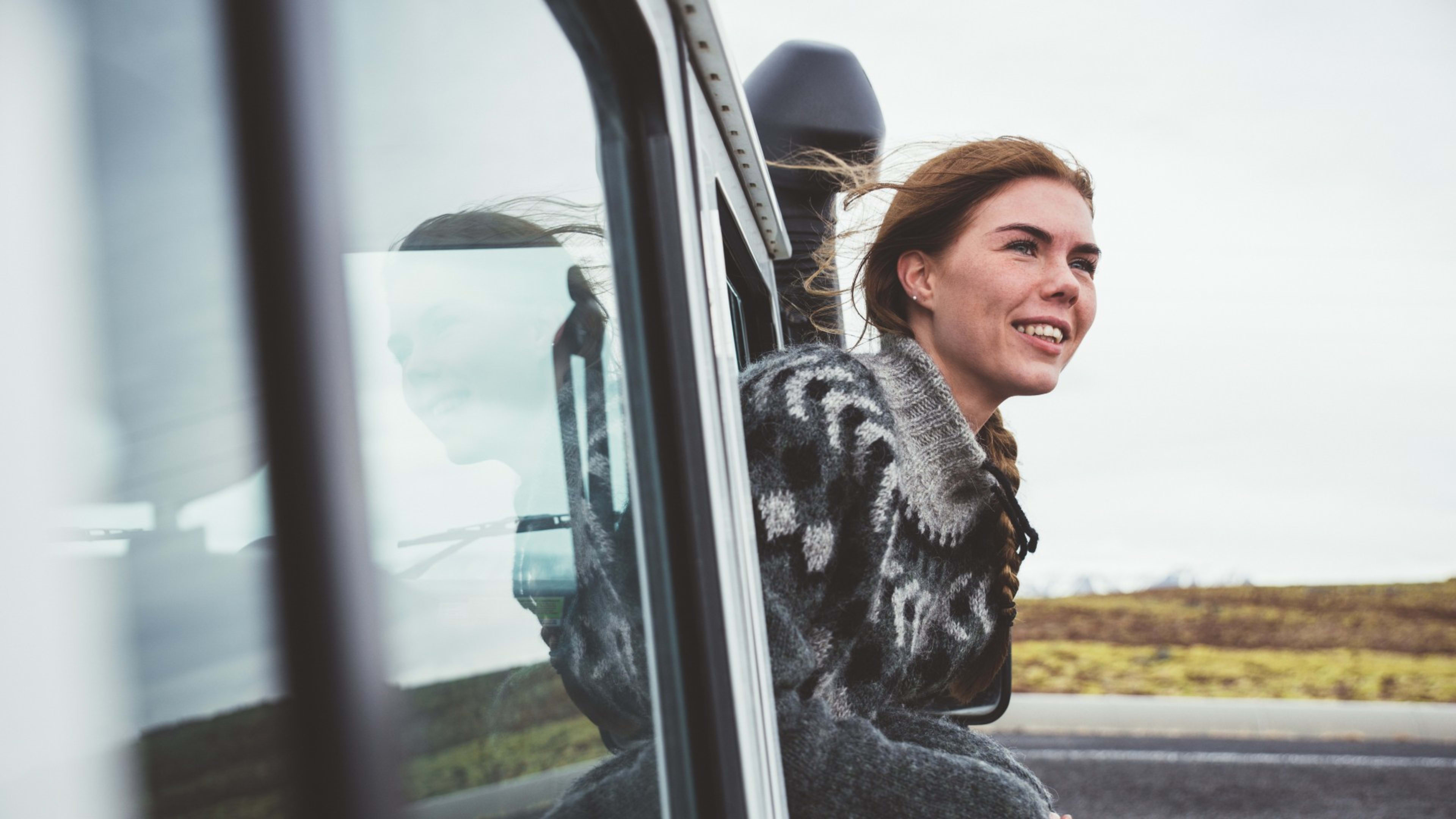 An Icelandic woman leaning out of a car window