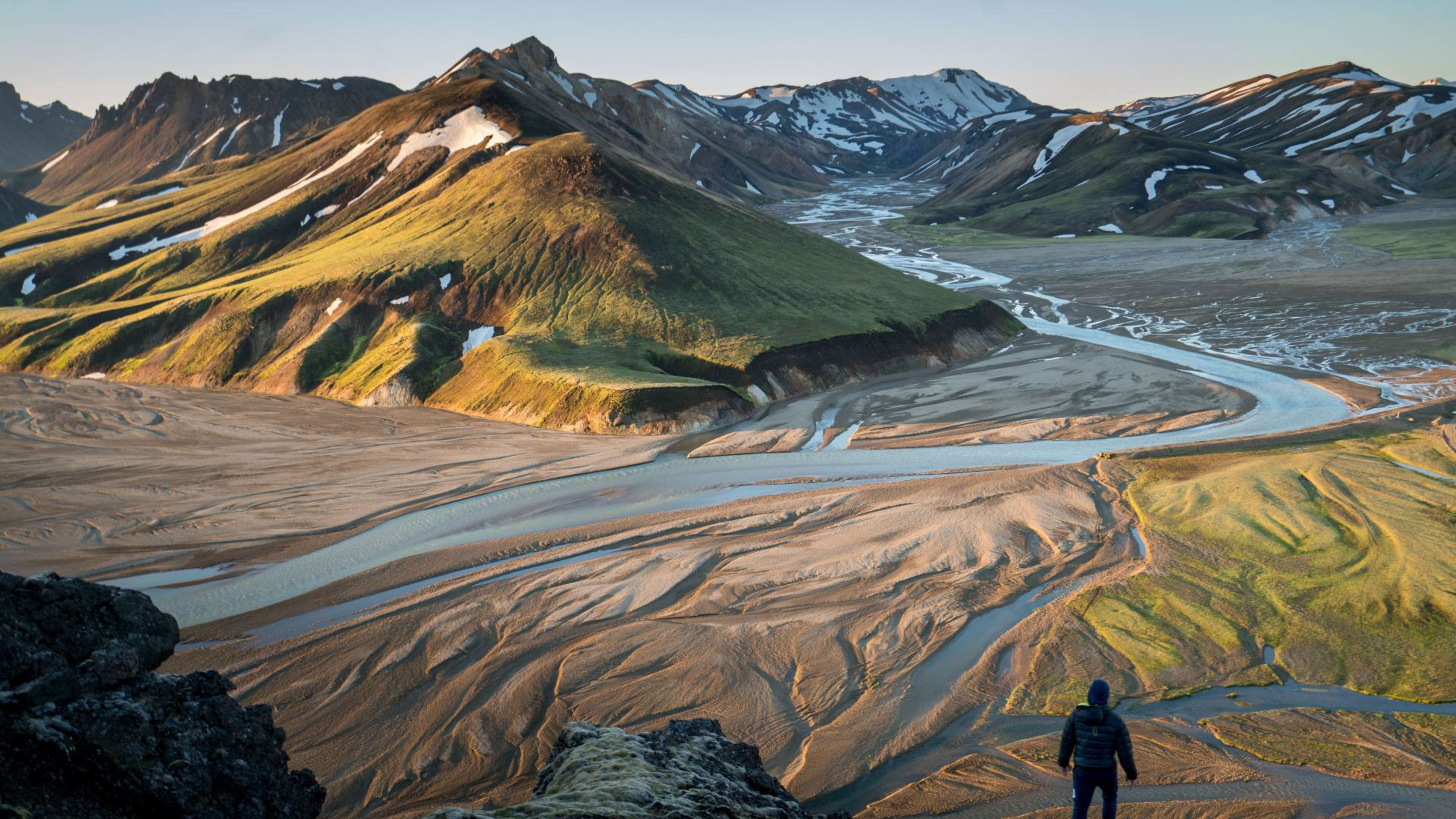 A man standing in front of mountains at Landmannalaugar