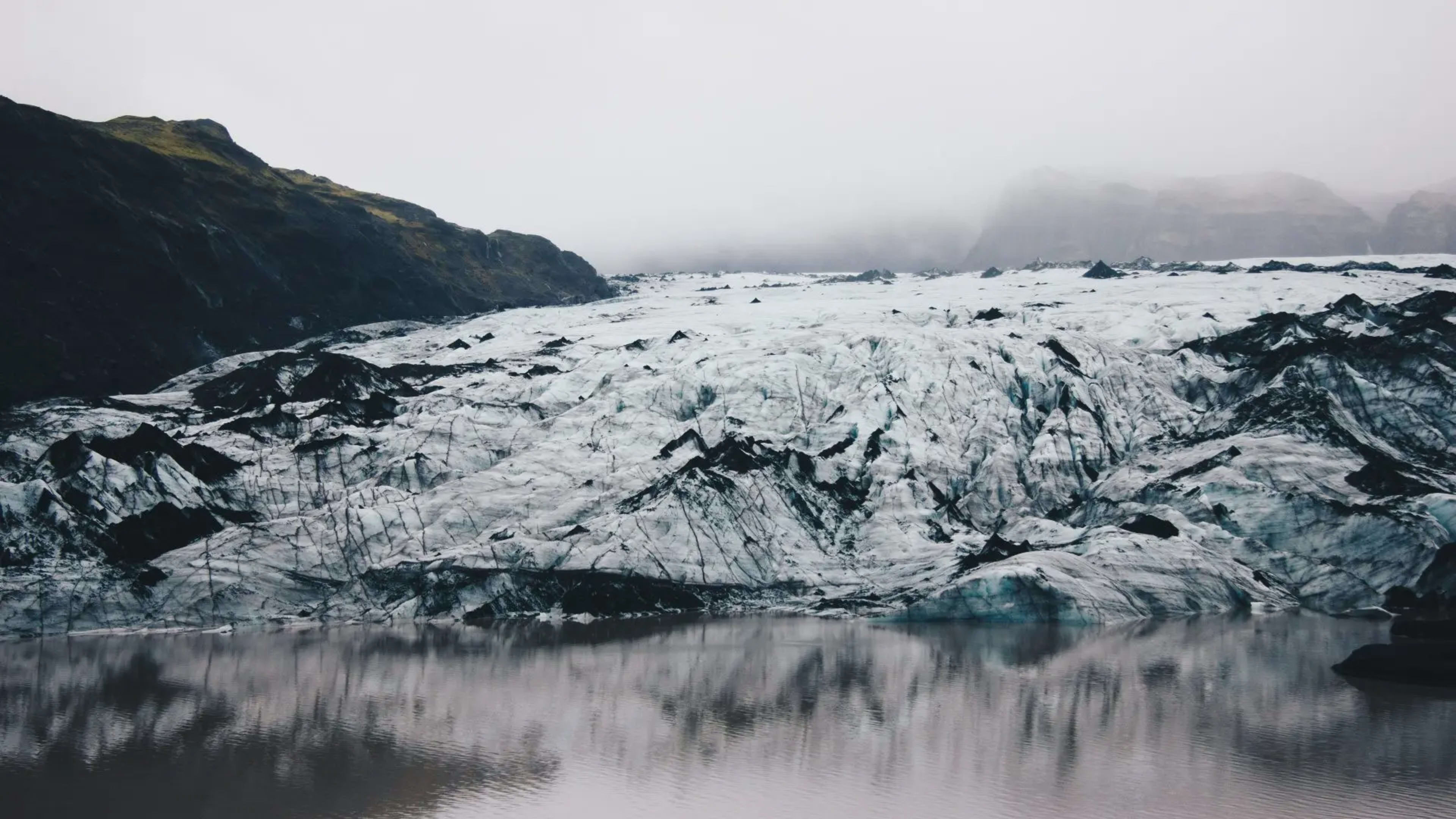 glacier in the mist with blurry reflection in the water