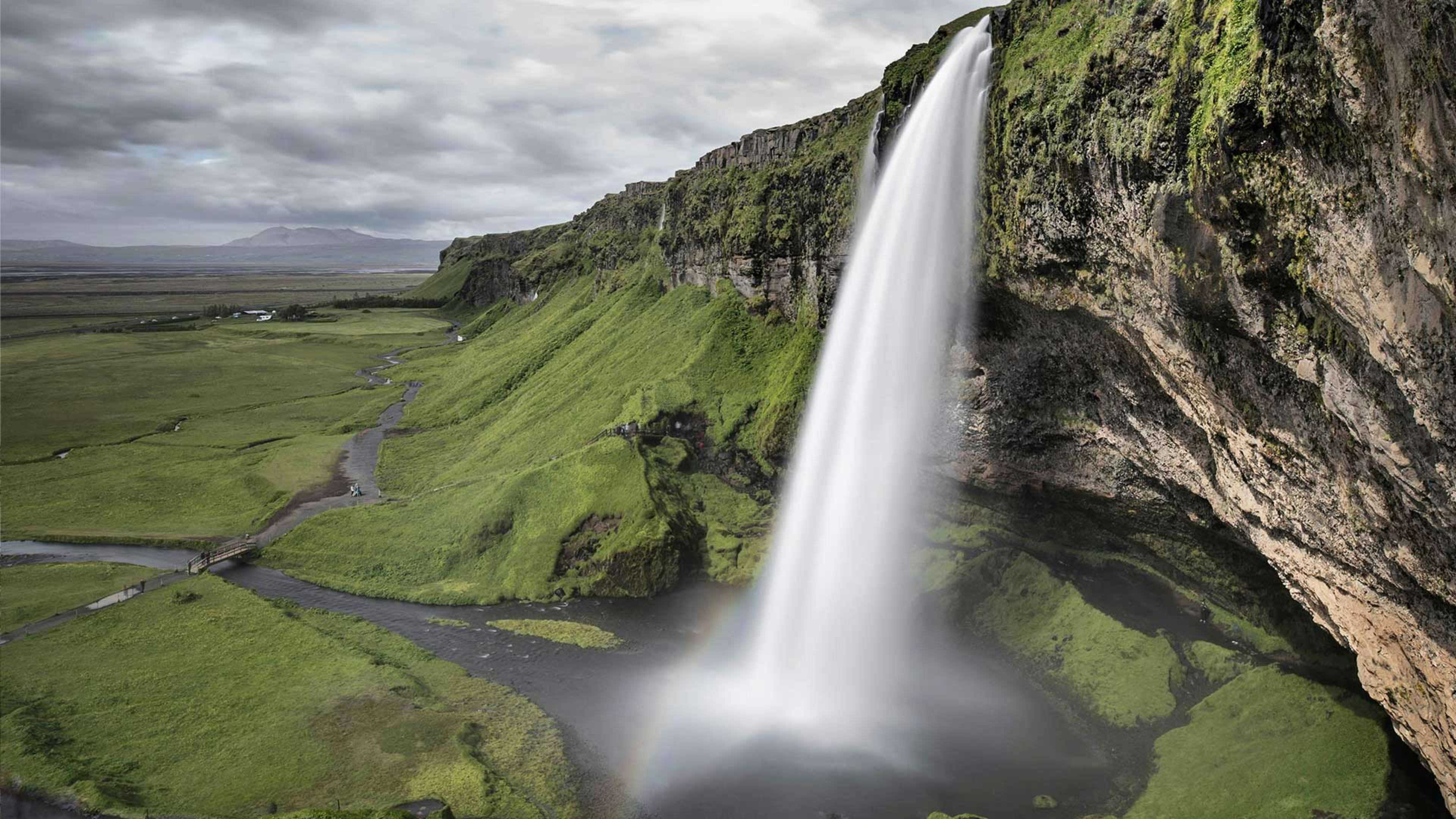 Side view of Seljalandsfoss and the surrounding green landscape