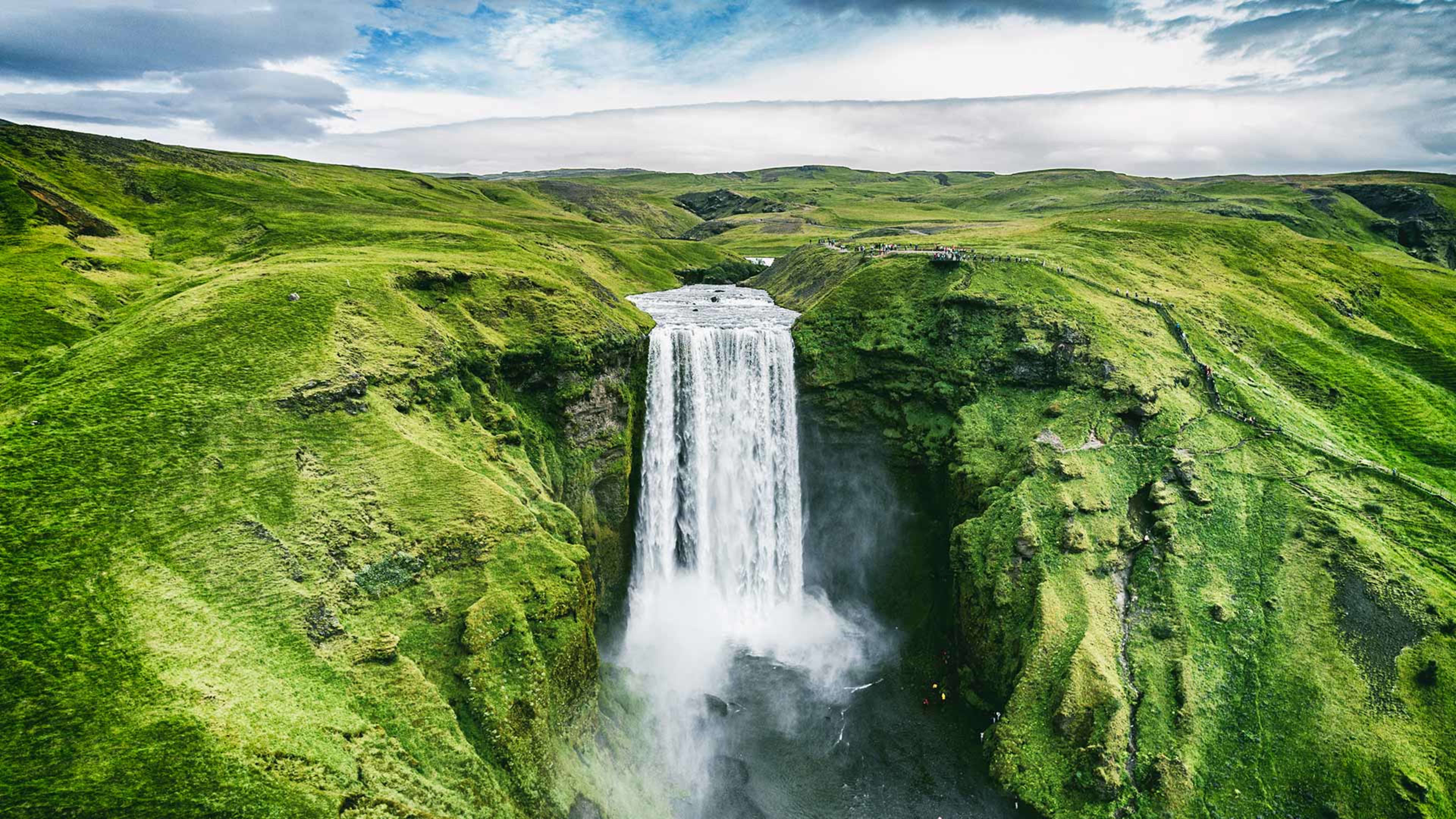 Aerial view of Skógafoss surrounded by lush green landscape