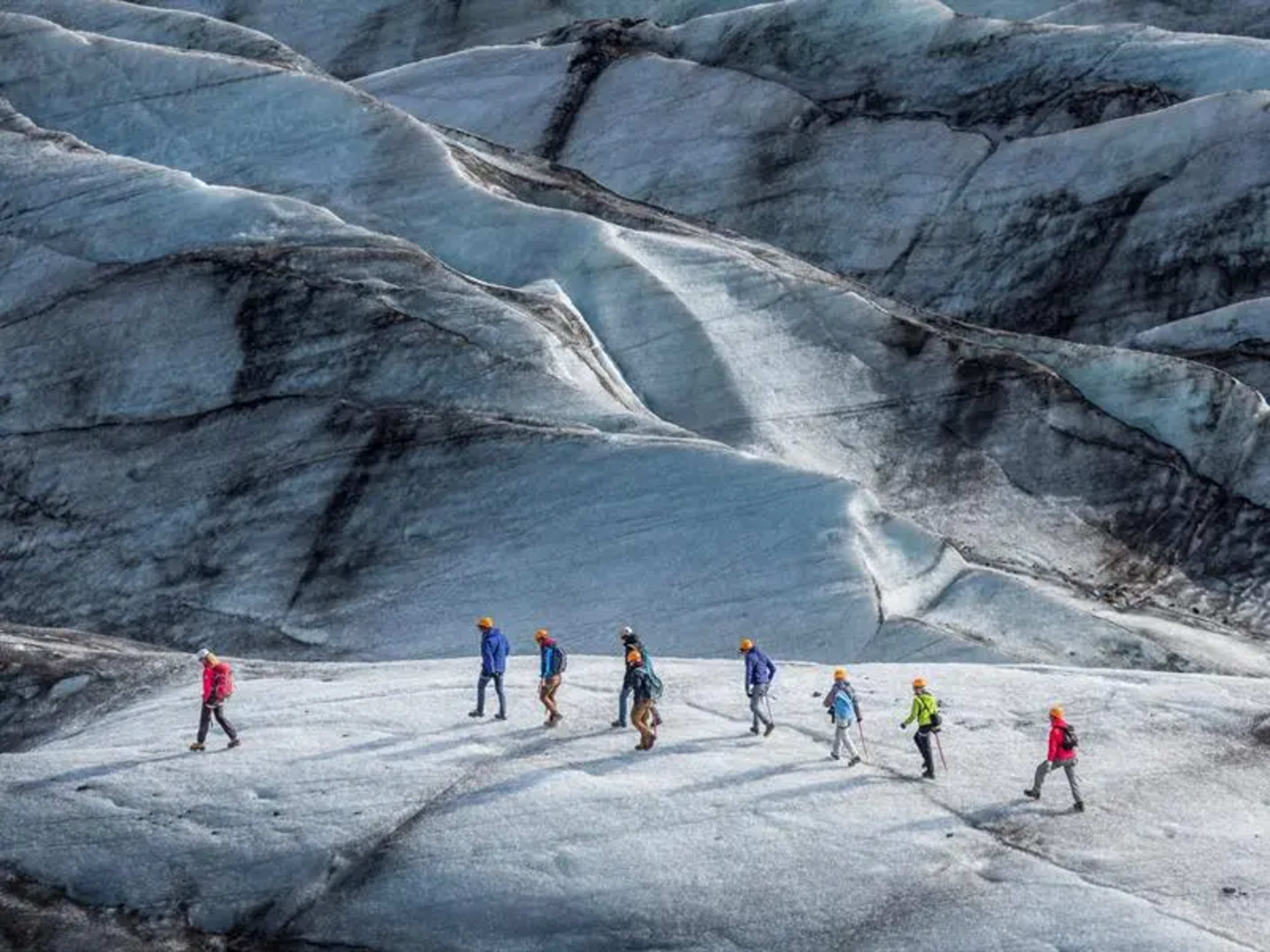 Group of people walking on a glacier 