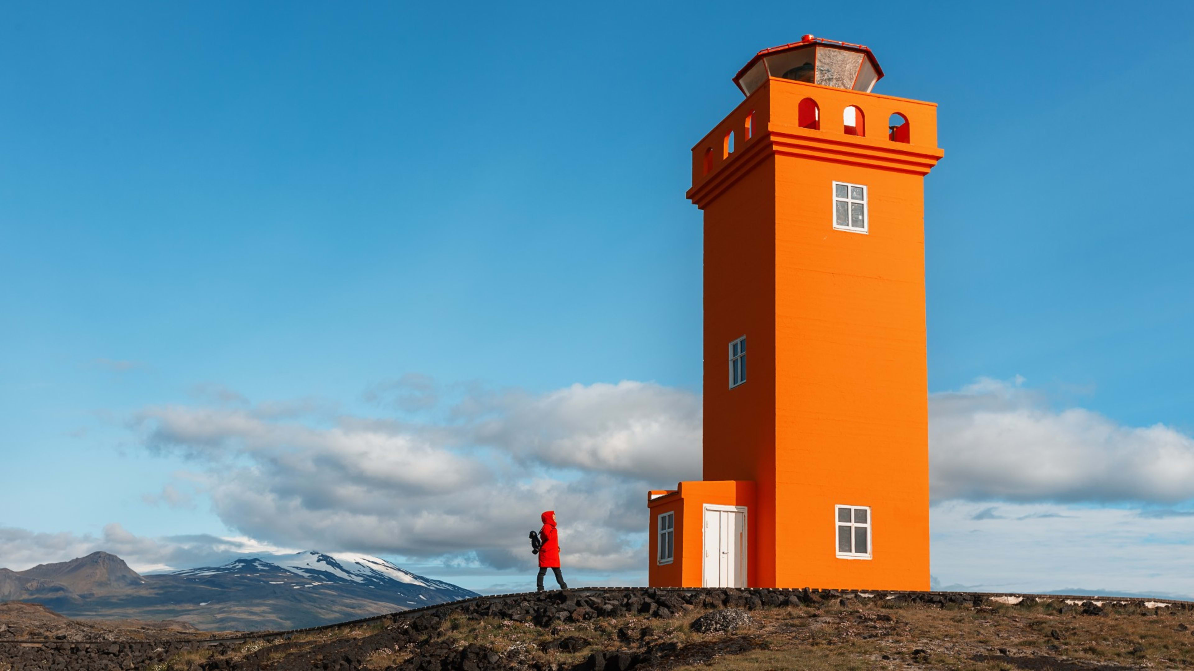 A woman next to the Svörtuloft lighthouse on the Snæfellsnes peninsula