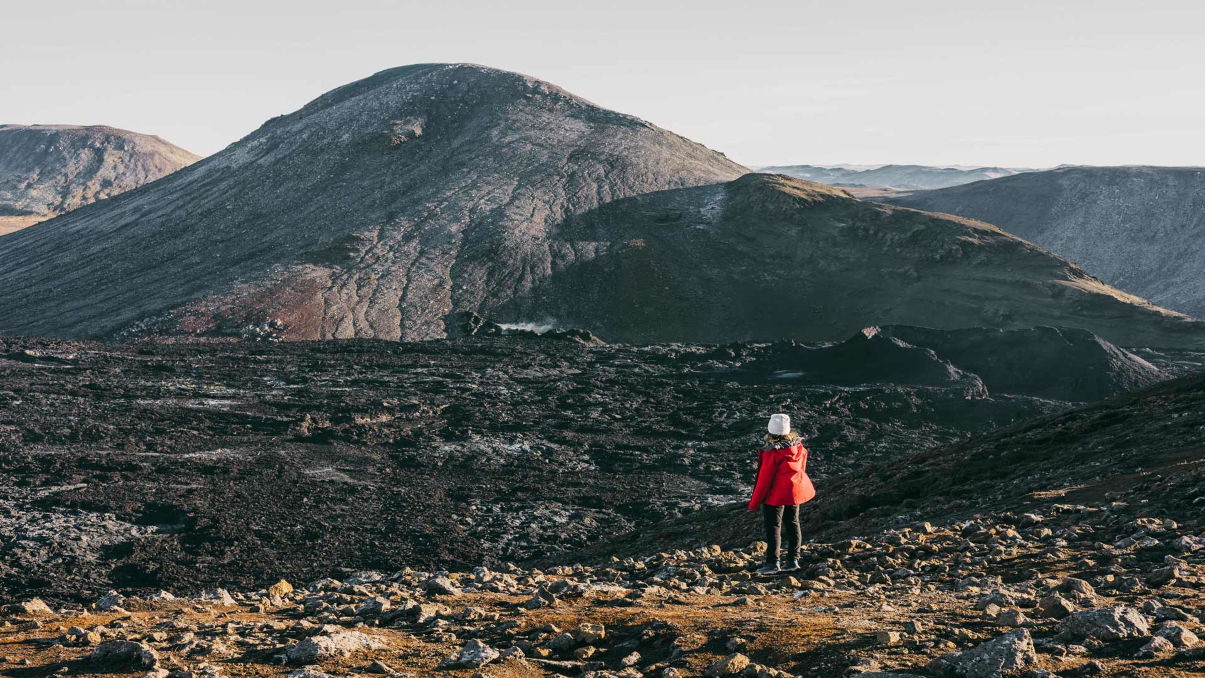 A woman standing by the rocky Fagradalsfjall volcano