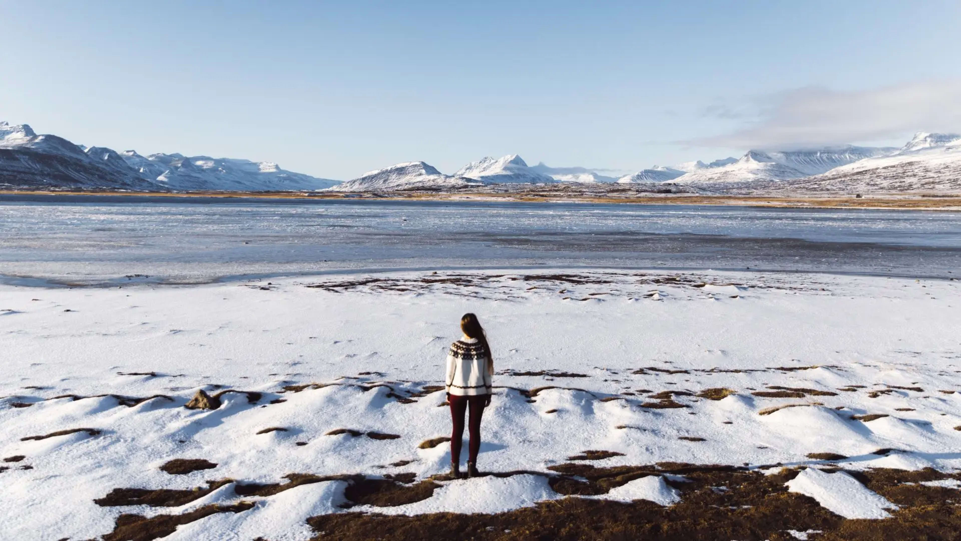 Woman standing in front of a frozen lake in Iceland