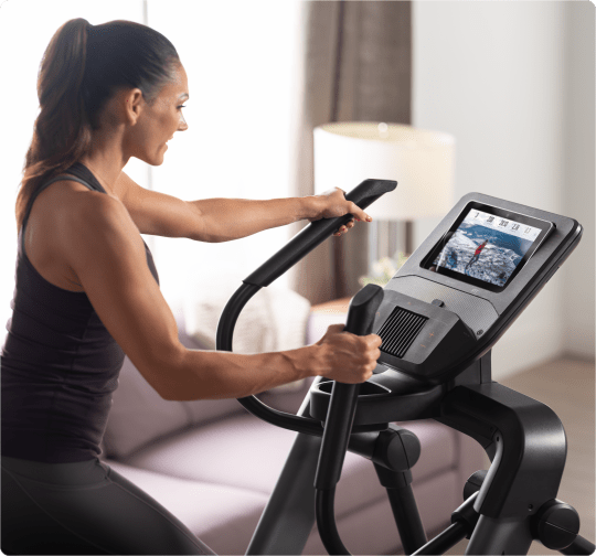 Woman working out with an iFIT trainer on the FS10i.