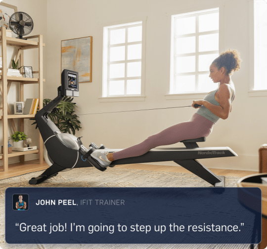 Woman pulling back the handle bars on her rower, her iFIT trainer virtually guiding her through a workout in her home.