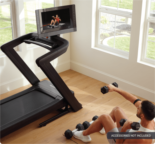 man exercising beside the 2450 treadmill which has its console swiveled to the right