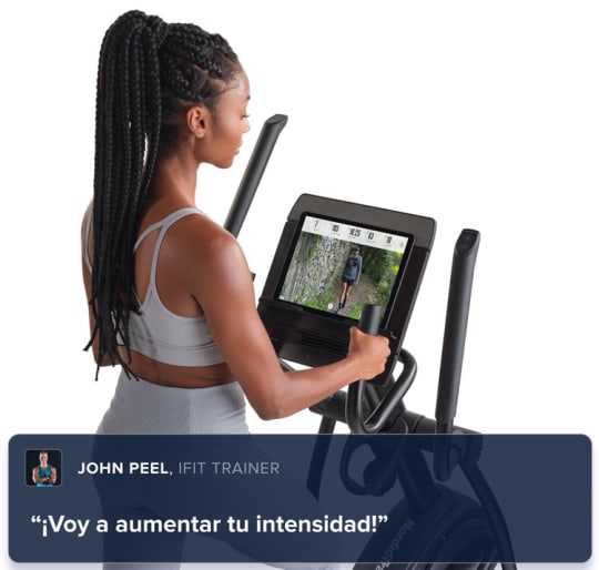 Man engaged in a workout on his AirGlide elliptical, watching his iFIT trainer on the console