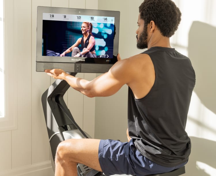 man adjusting the rotating display on the new rw900 rower