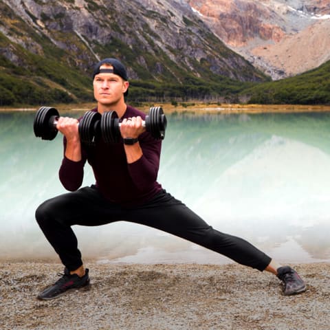 Coach stretching while curling two dumbbells