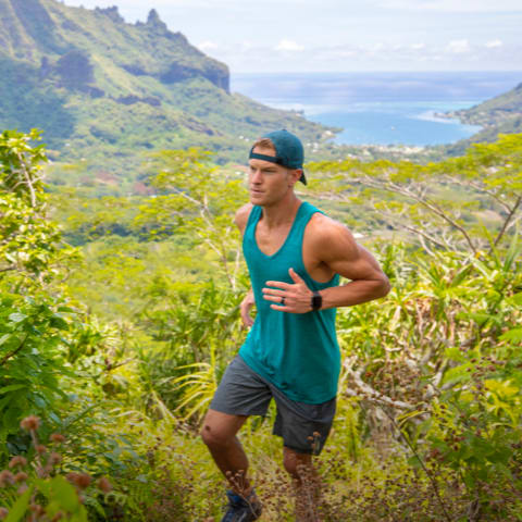 Trainer on an incline through a bright green foraged island trail.