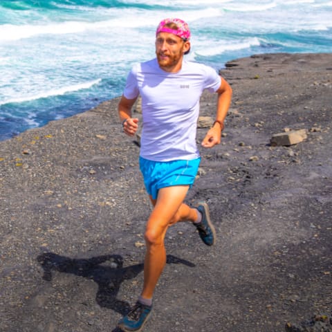 Coach running on a dark sanded beach