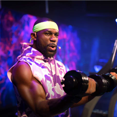 Trainer in studio stepped off of treadmill to do a dumbbell workout.