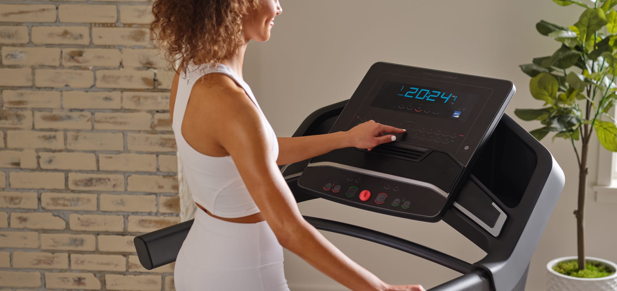 Woman doing a workout on the Carbon TLX treadmill.