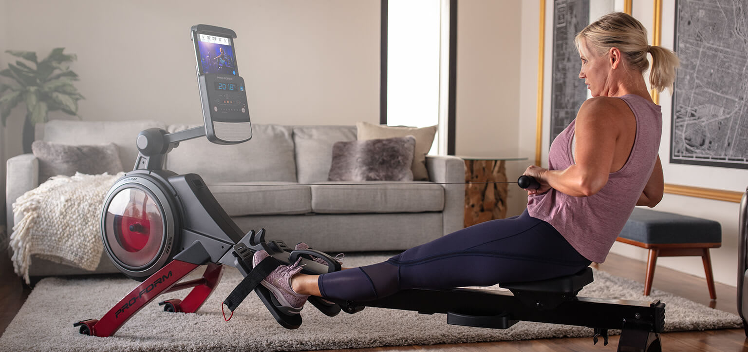 Woman rowing in her living room.