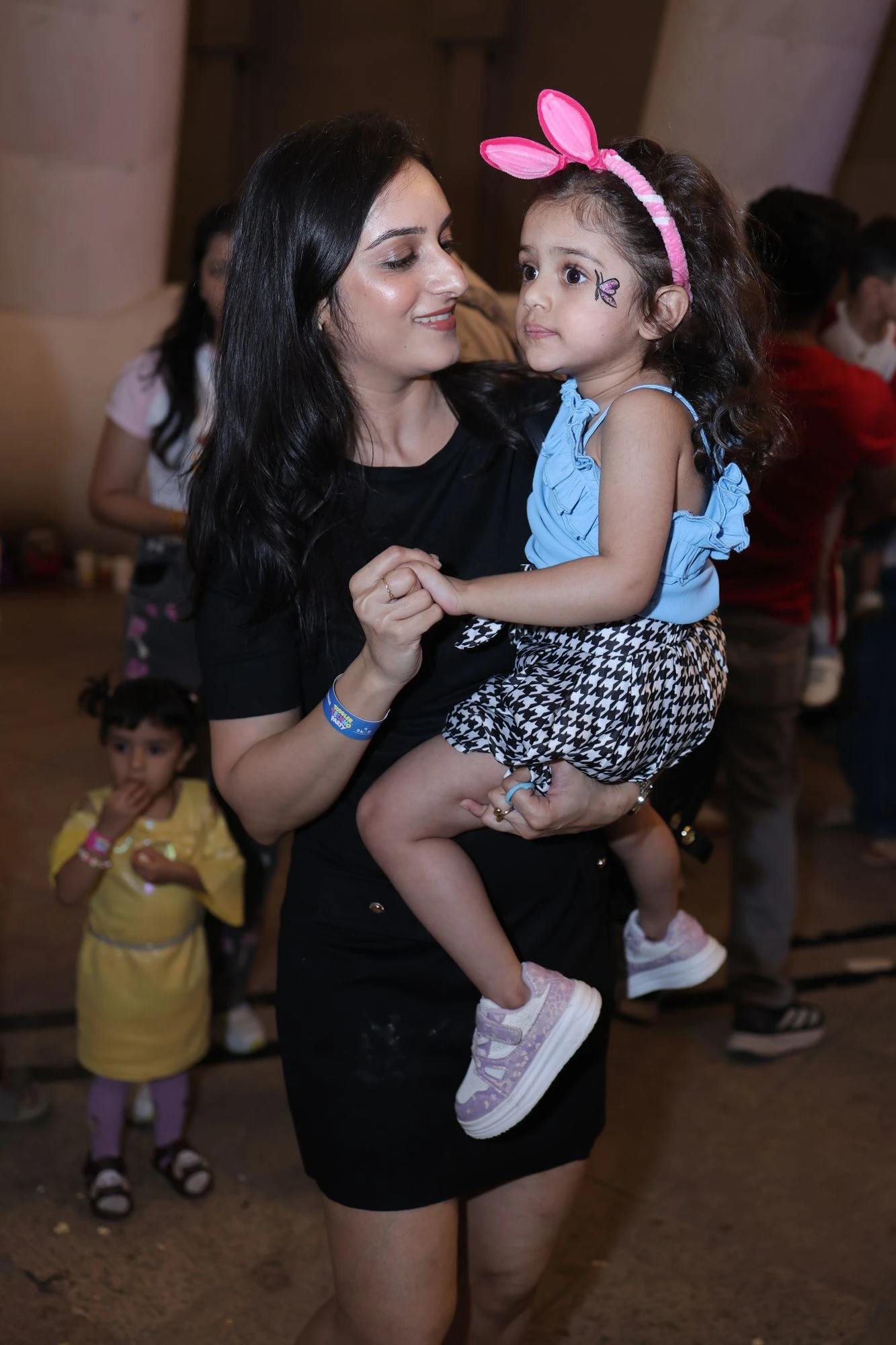 Mother holding her daughter in bunny ears at Toddler Techno Party