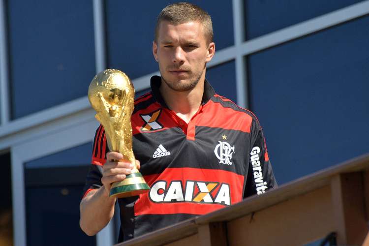 OFF - Com camisa do Flamengo, Podolski posa com troféu no Rio