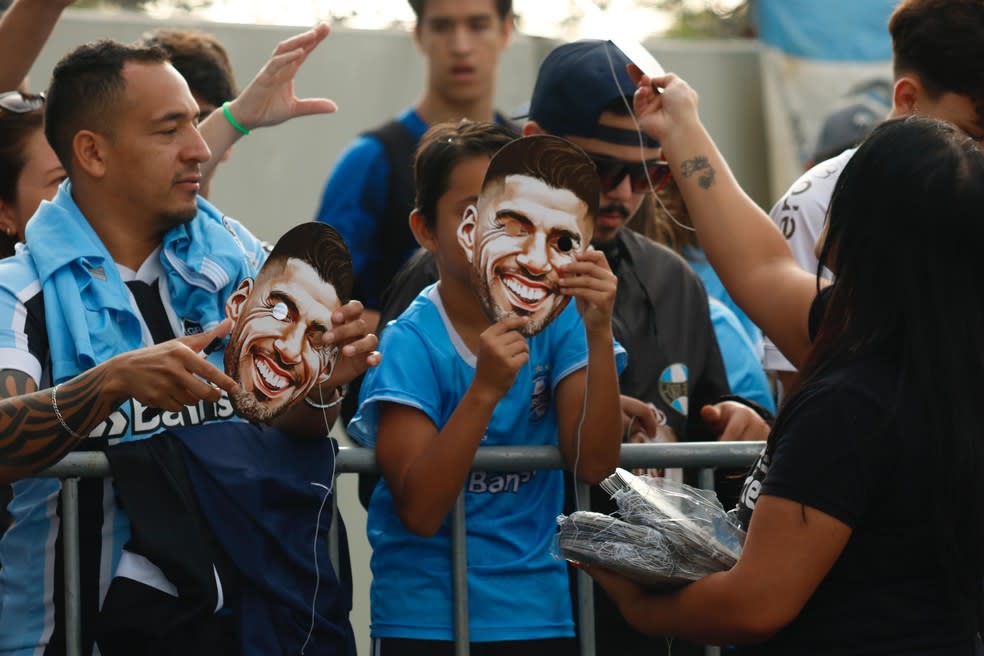 Torcida do Grêmio usa máscaras de Suárez no aeroporto — Foto: João Victor Teixeira