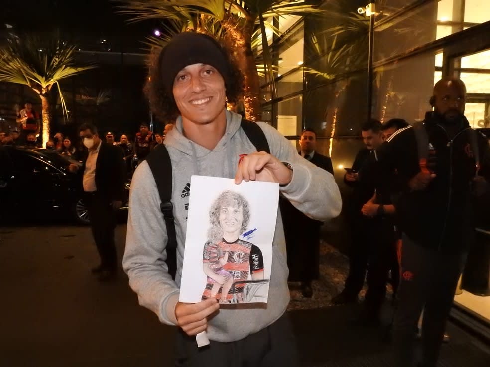 Com presente e bolo de aniversário, David Luiz recebe carinho de fãs na chegada a Curitiba