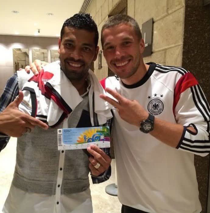 Podolski presenteia o amigo André Santos com ingresso da final da Copa