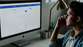 Worker at computer to show our online portal and quality assurance process