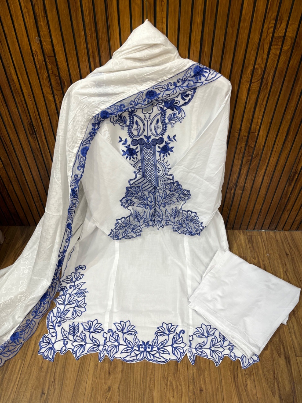 This elegant white cotton suit features beautiful royal blue thread embroidery
