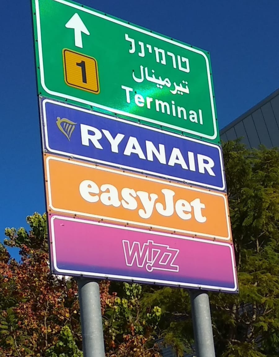 כמה עולה מזוודה בטיסות לואו קוסט עם Pegasus, Ryanair, easyJet או Wizz air? שלט הכוונה לחניה בטרמינל 1 לטסים עם Ryanair, easyJet, Wizz air - האם צריך לשלם על מזוודה?