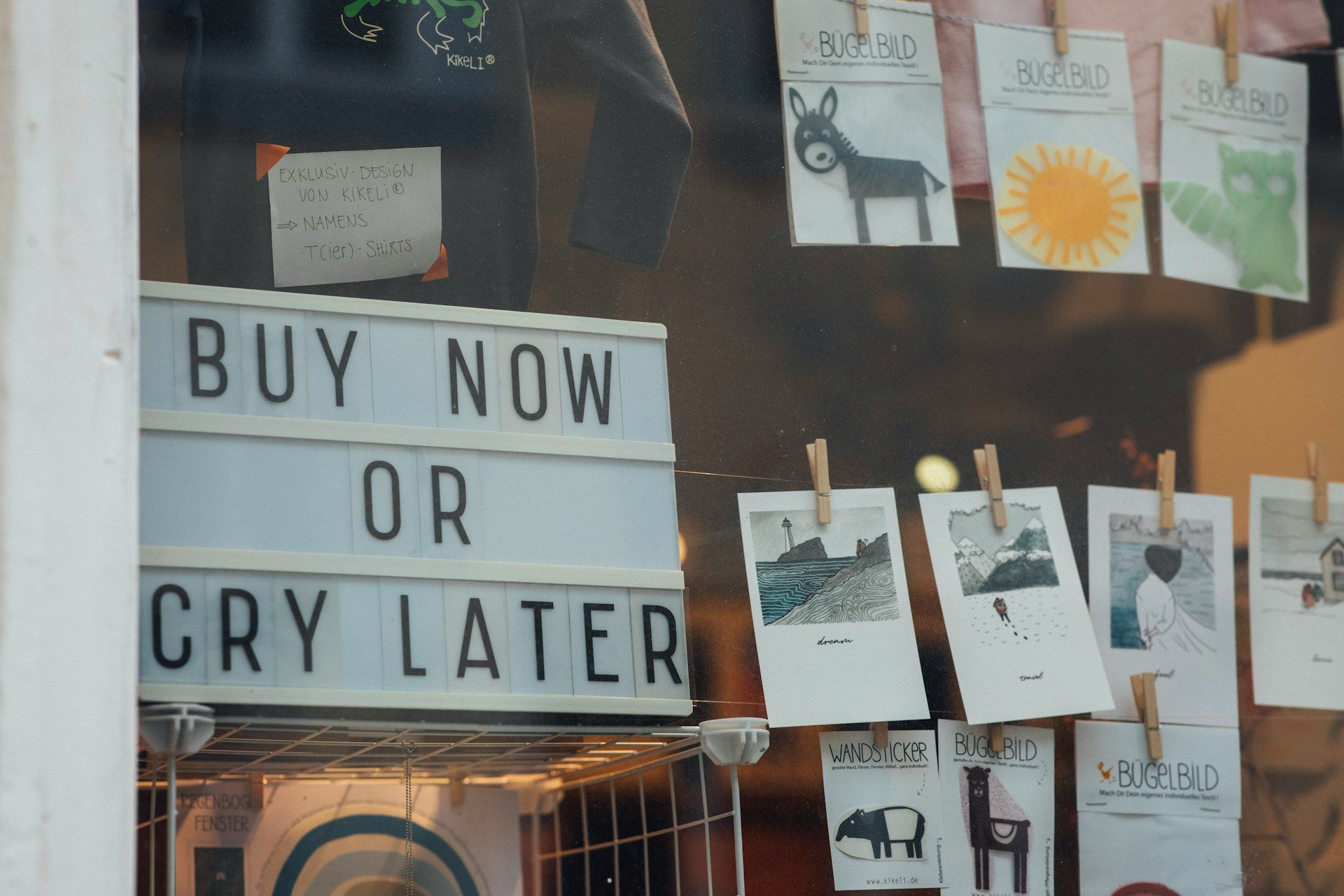 A fun sign in a shop window that reads “Buy now or cry later” as their CTA