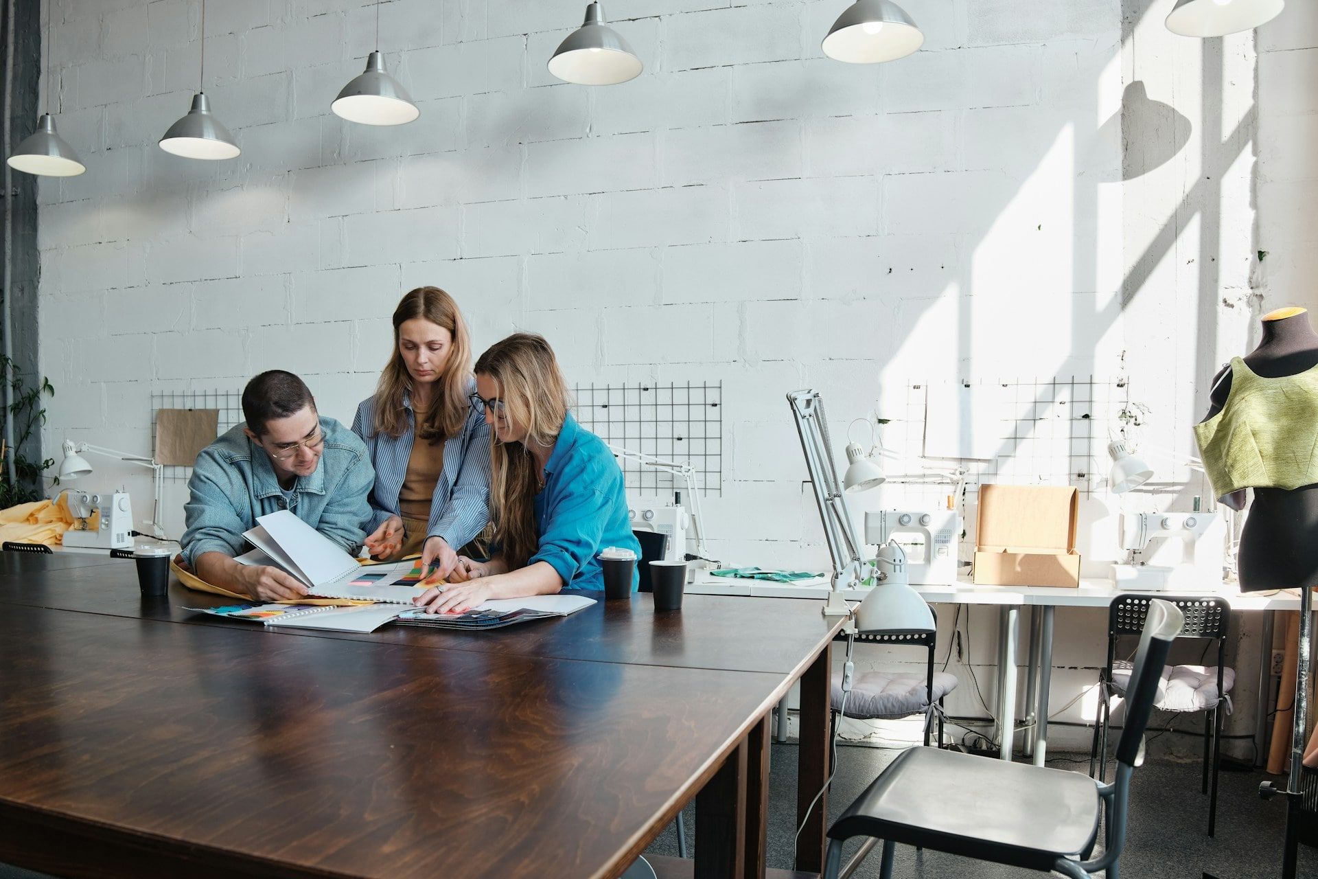 A group of web designers working on a wooden table to develop a project